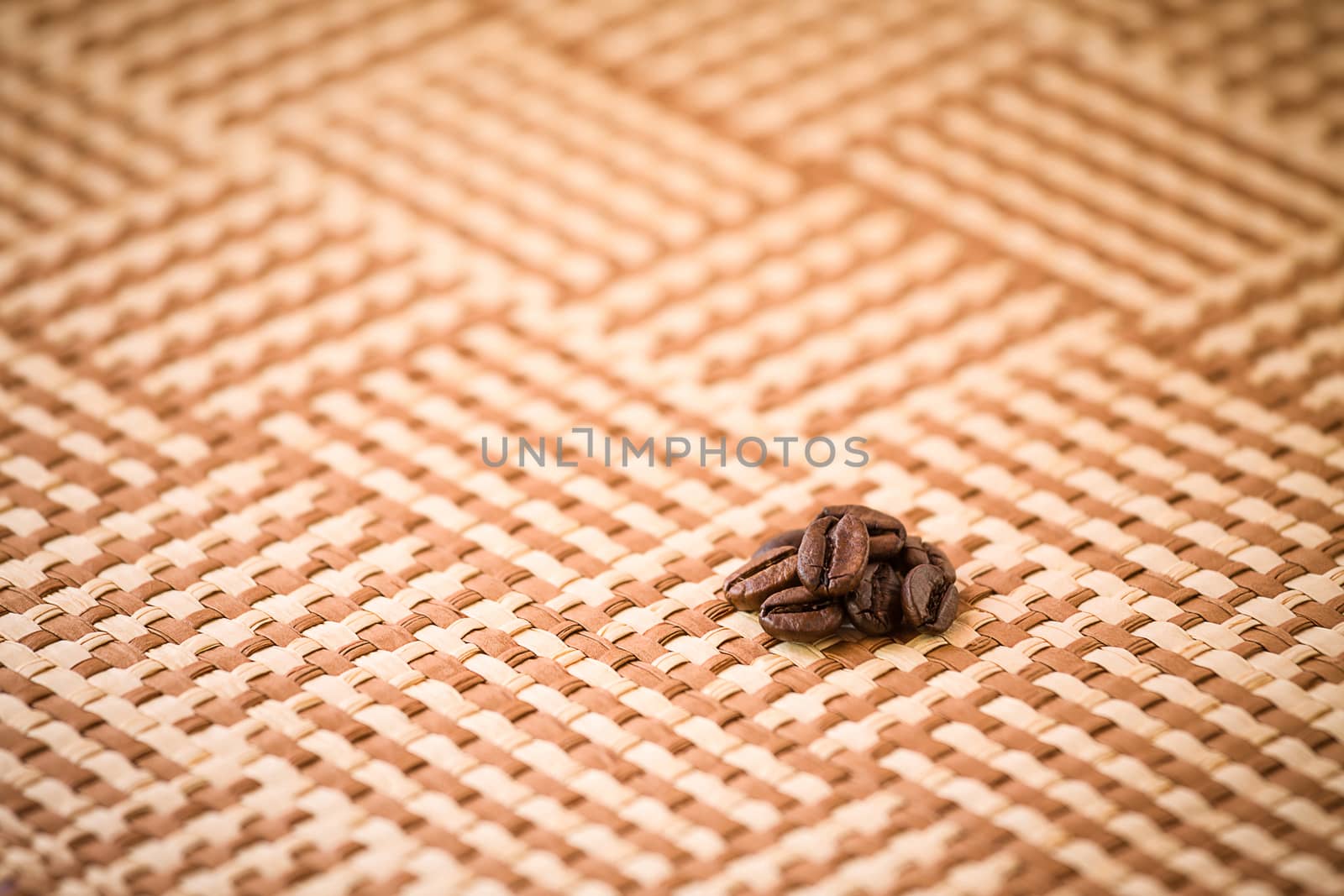 Some coffee beans on a squared tablecloth