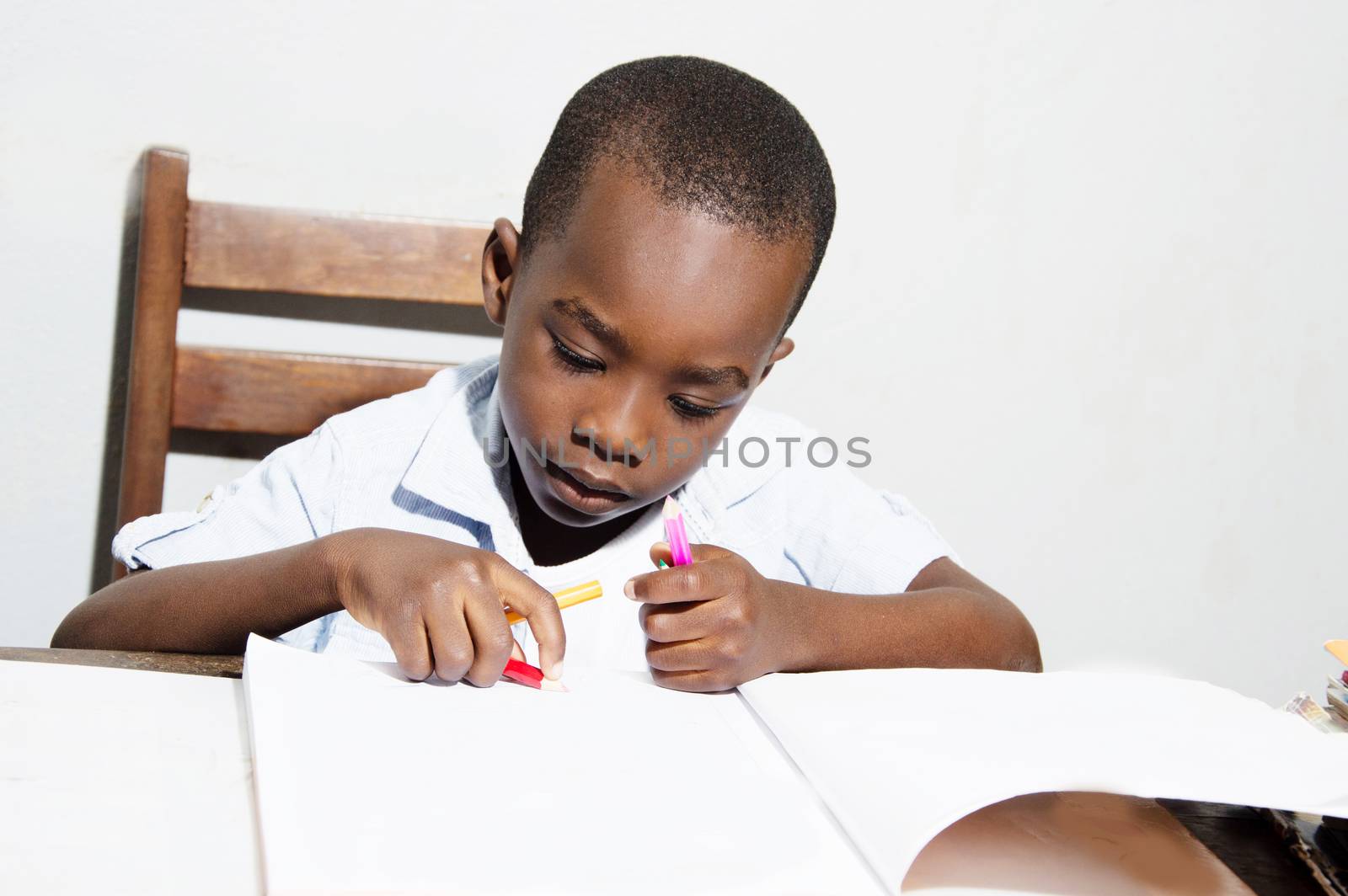 Child crayon drawings in his book with different color.