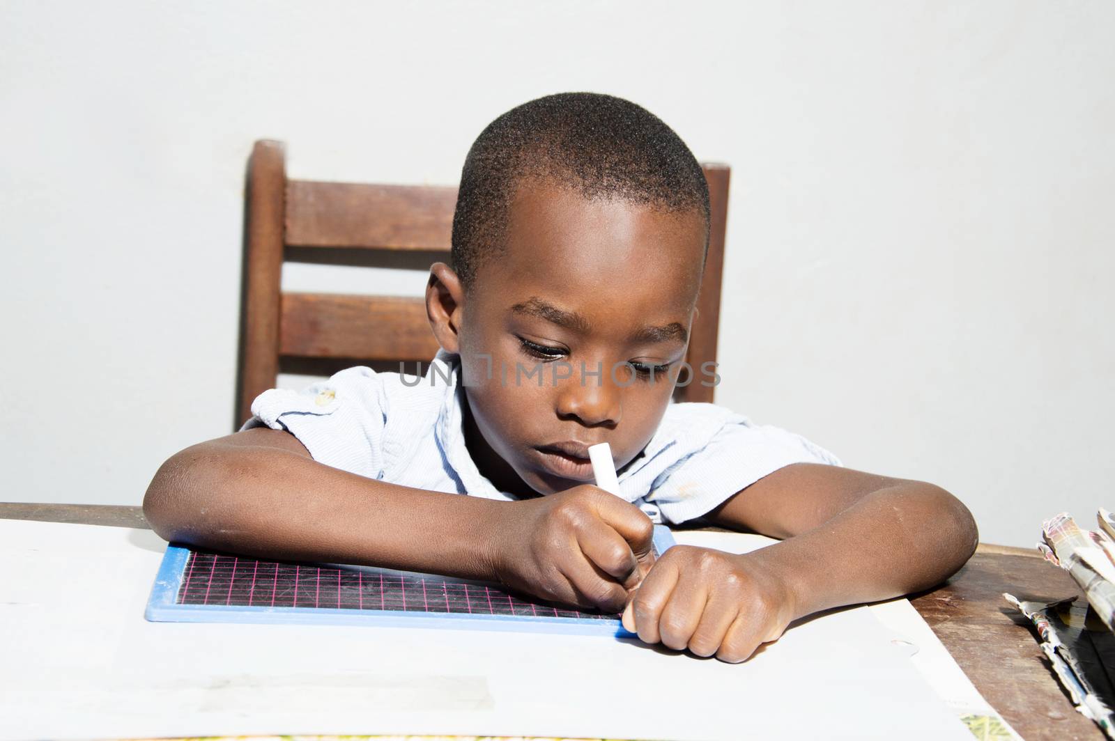 This child written with a chalk stick in hand.