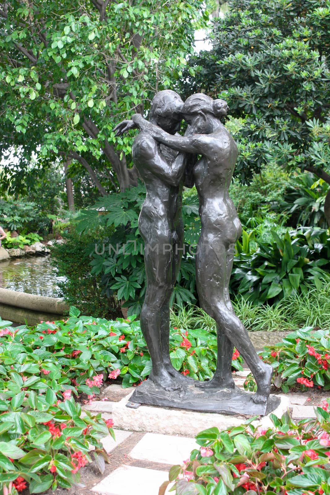 A loving couple embraces. Monument in the park