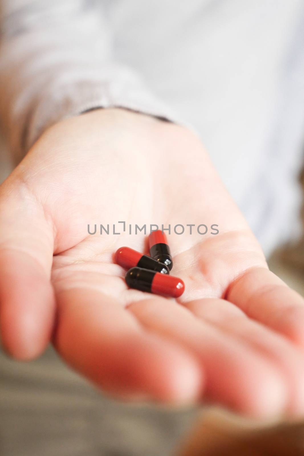 Medicine pills or capsules in hand, palm or fingers. Drug prescription for treatment medication..Antibiotic, painkiller closeup.