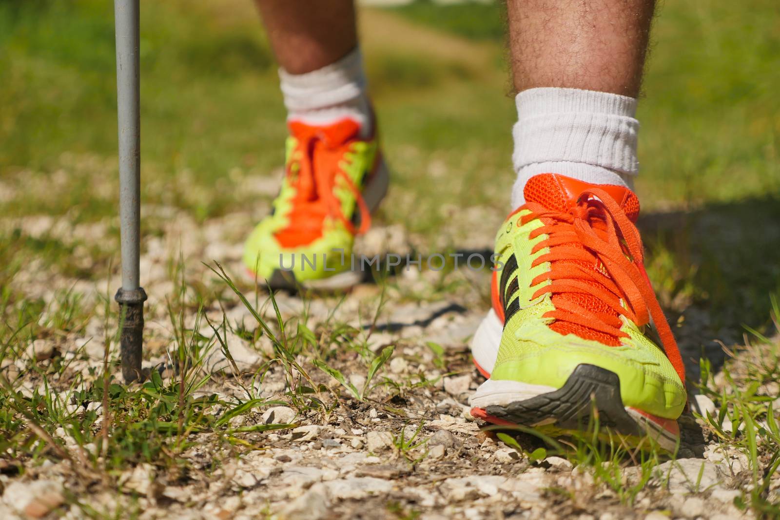 Man walking on sidewalk, sport shoes closeup, France
