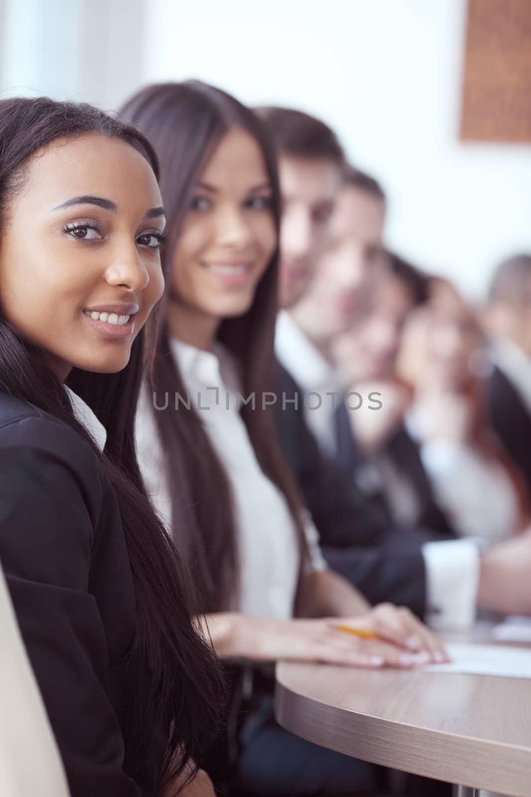 Business people sitting in a row and working, focus on pretty woman