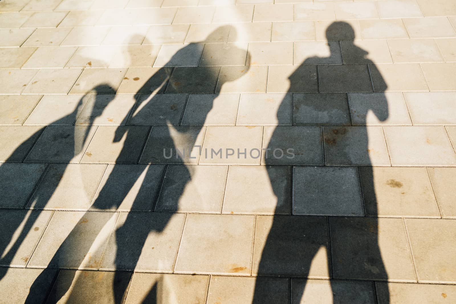 People casting shadows on the pavement by stevanovicigor
