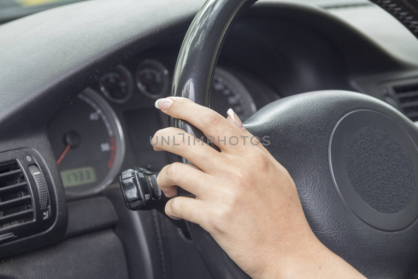 the girl with the manicure keeps hands on the steering wheel of the car