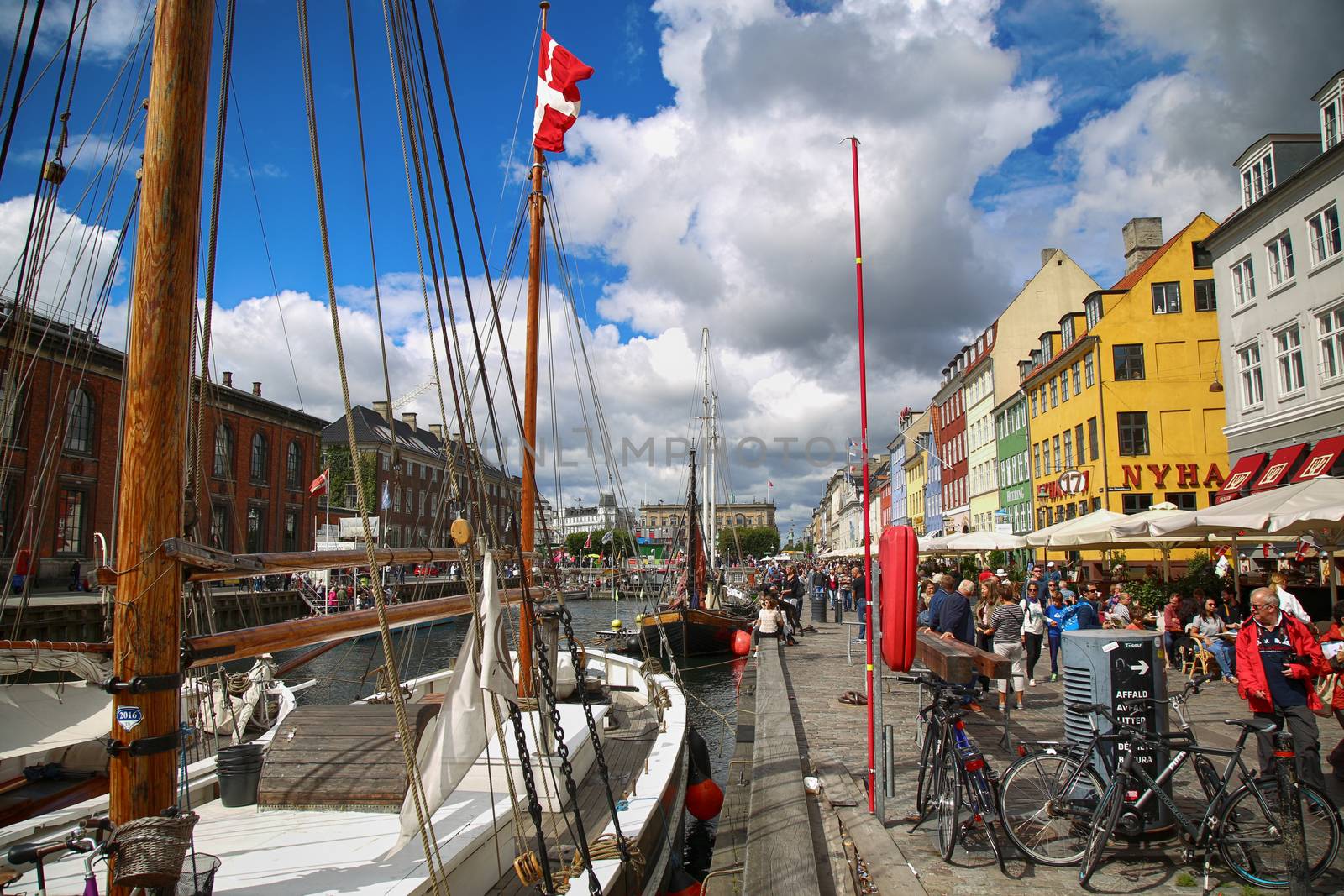 COPENHAGEN, DENMARK - AUGUST 14, 2016: Boats in the docks Nyhavn, people, restaurants and colorful architecture. Nyhavn a 17th century harbour in Copenhagen, Denmark on August 14, 2016.