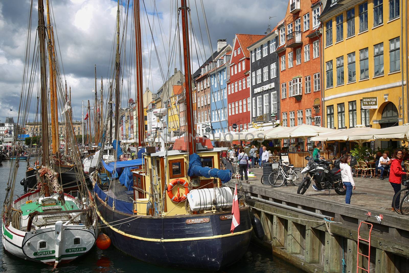 COPENHAGEN, DENMARK - AUGUST 14, 2016: Boats in the docks Nyhavn, people, restaurants and colorful architecture. Nyhavn a 17th century harbour in Copenhagen, Denmark on August 14, 2016.