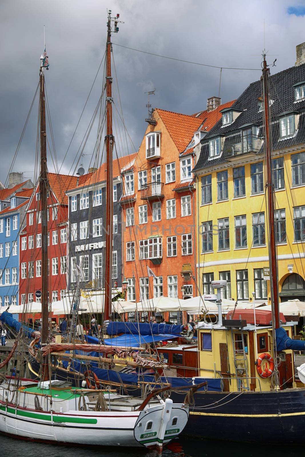 COPENHAGEN, DENMARK - AUGUST 14, 2016: Boats in the docks Nyhavn, people, restaurants and colorful architecture. Nyhavn a 17th century harbour in Copenhagen, Denmark on August 14, 2016.