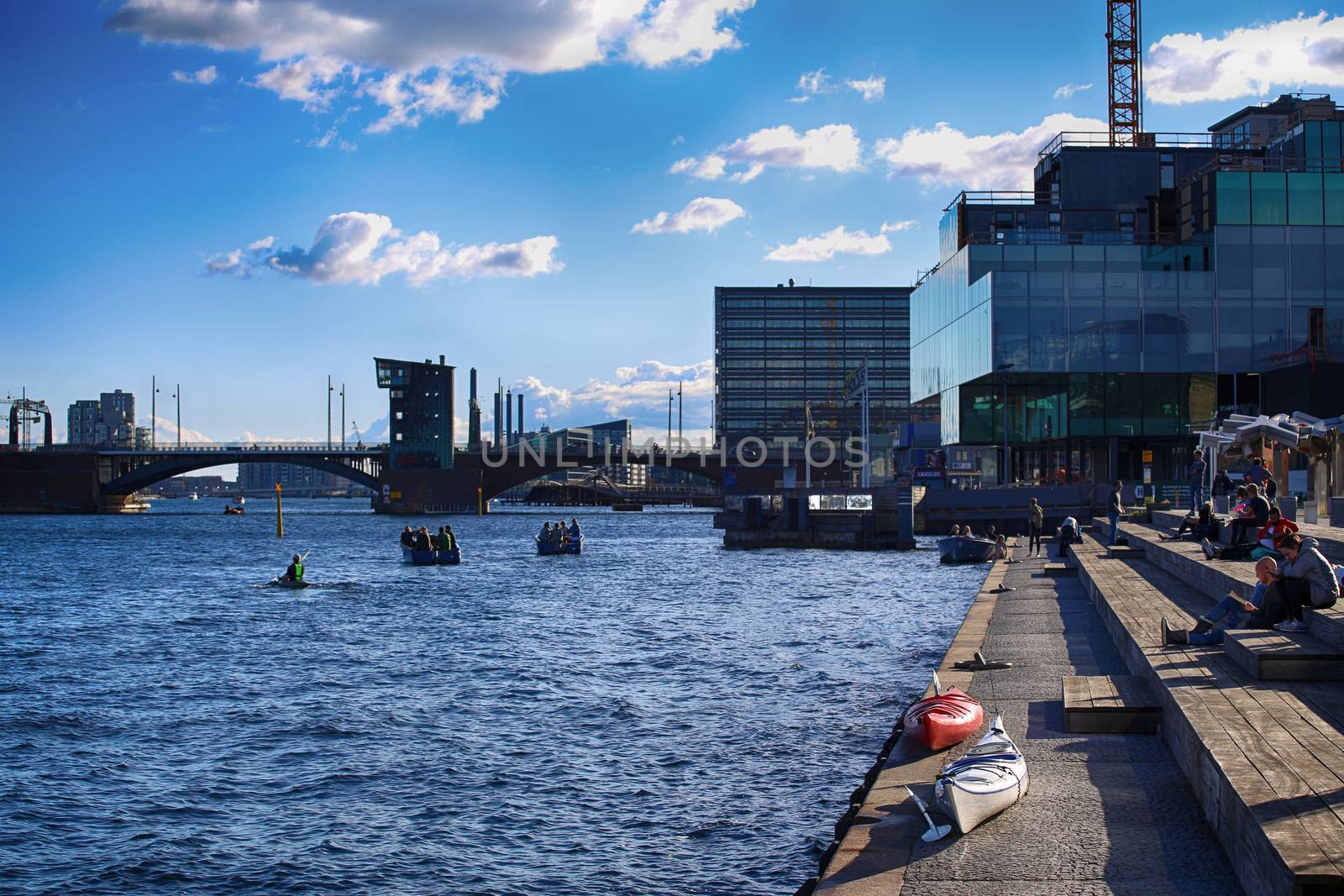 Copenhagen, Denmark – August  16, 2016: People relax in one of the waterfront and views of cities and bridges from The Black Diamond, The Copenhagen Royal Library in Copenhagen, Denmark