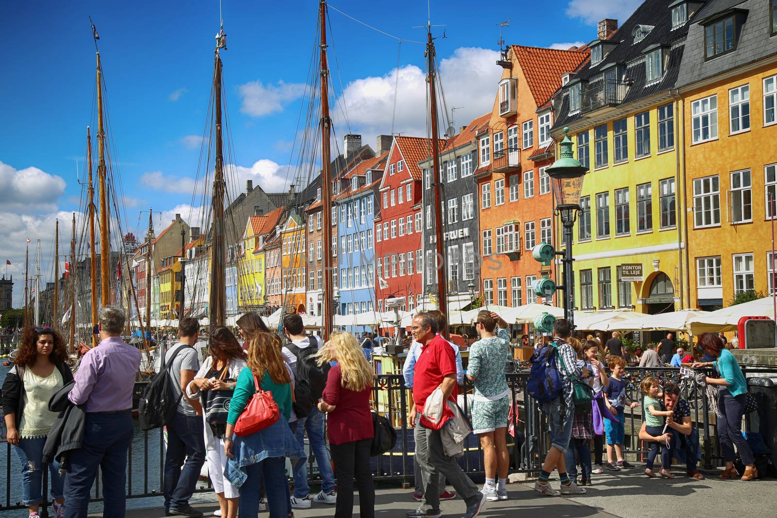 Copenhagen, Denmark – August  15, 2016: Boats in the docks Nyhavn, people, restaurants and colorful architecture. Nyhavn a 17th century harbour in Copenhagen, Denmark