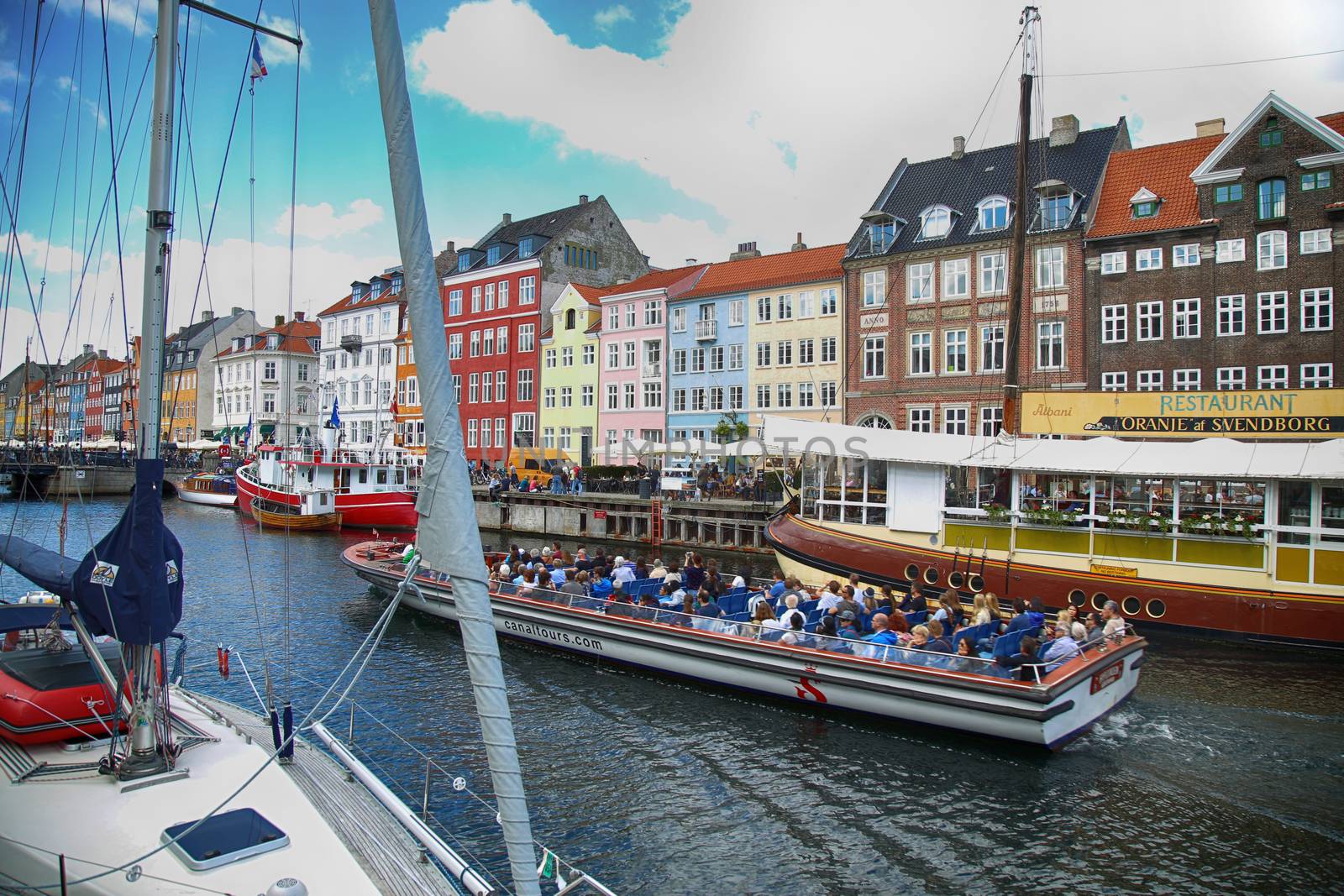 Copenhagen, Denmark – August  15, 2016: Tourists enjoy and sightseeing in tourist boat at the canal Nyhavn. The boat is loaded with sightseeing tourist people in Copenhagen, Denmark
