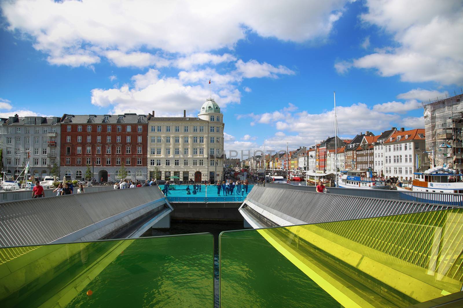 Copenhagen, Denmark – August  15, 2016: View on docks Nyhavn, people and colorful architecture from bridge Inderhavnsbroen -  Inner Harbour pedestrian and cyclist bridge in Copenhagen, Denmark