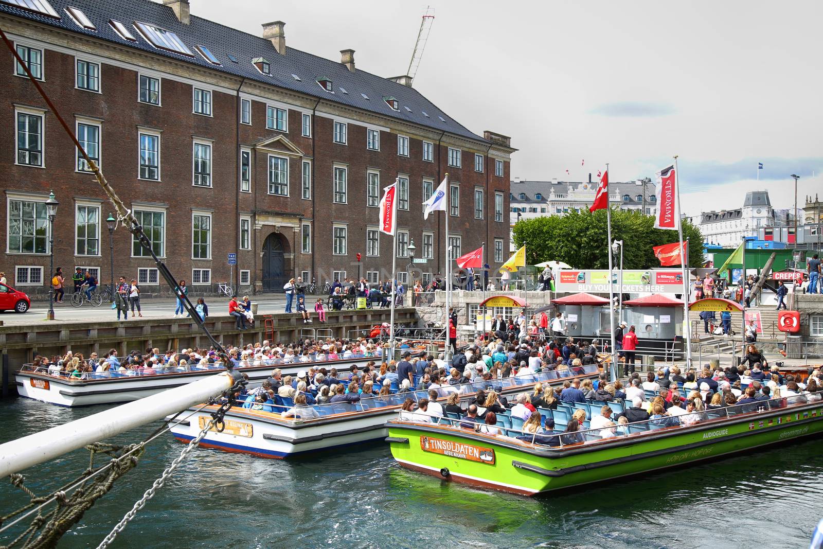 Copenhagen, Denmark – August  14, 2016: Tourists enjoy and sightseeing in tourist boat at the canal Nyhavn. The boat is loaded with sightseeing tourist people in Copenhagen, Denmark