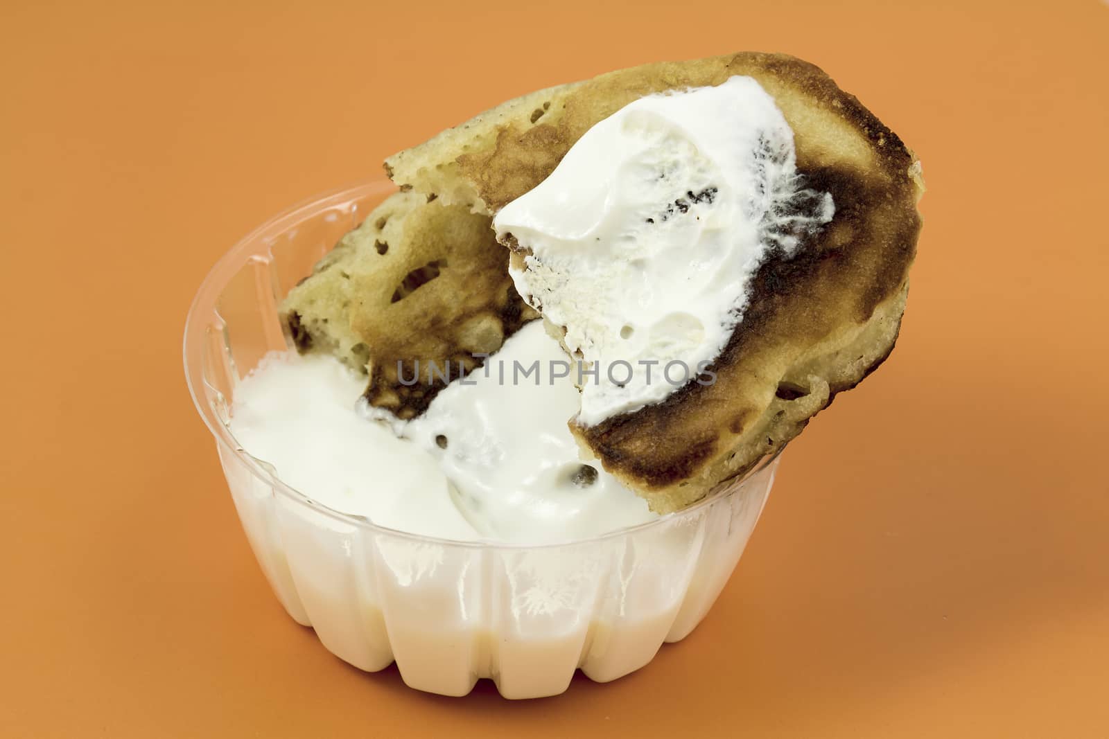 Closeup of a gingerbread pancake with sour cream on a yellow background