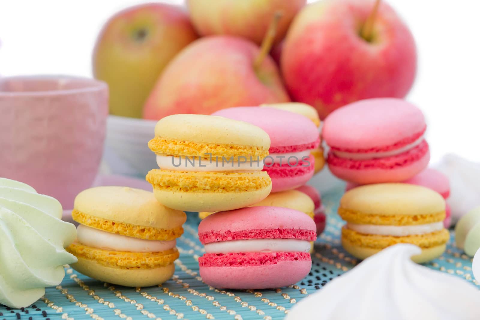 Still life of served coffee cups, macaroon cookies, marshmallows and apples