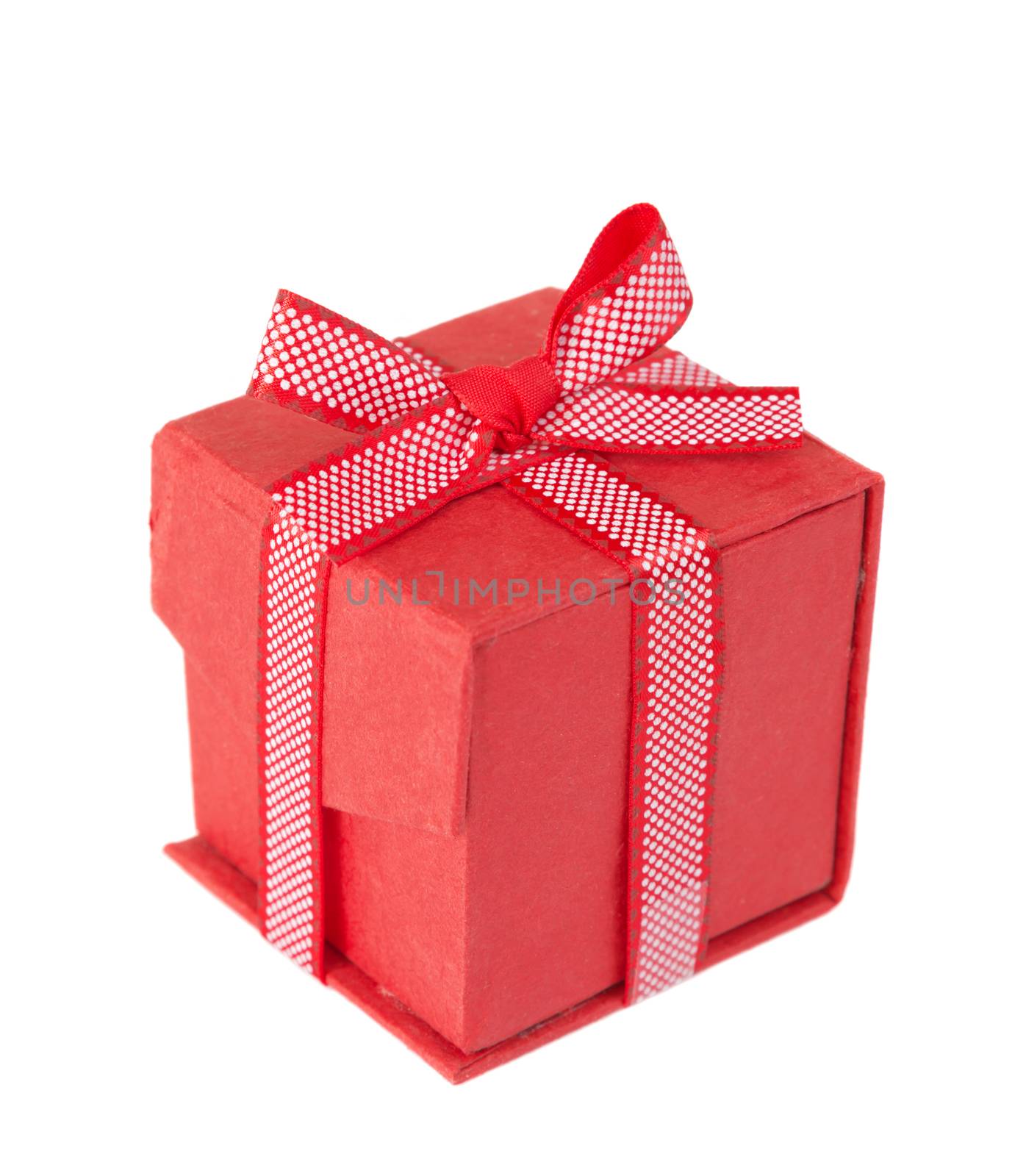 Red gift box tied with a decorative ribbon with polka dots, with bow, isolated on a white background