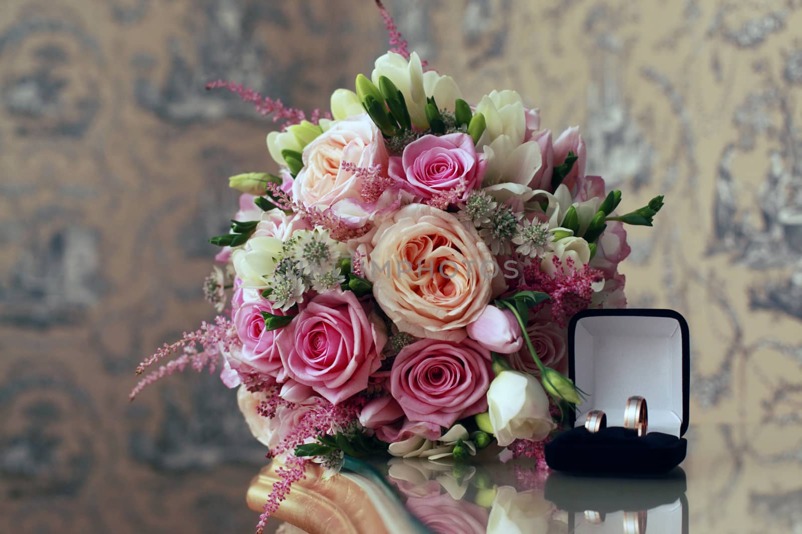 Beautiful wedding bouquet from pink roses and wedding ring