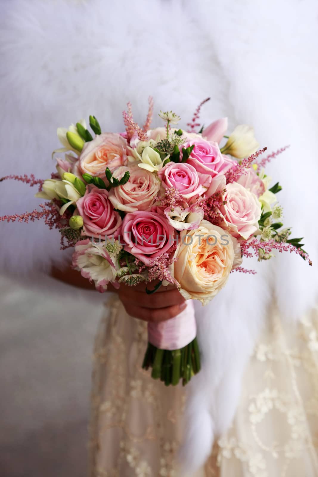 The bride holds a wedding bouquet