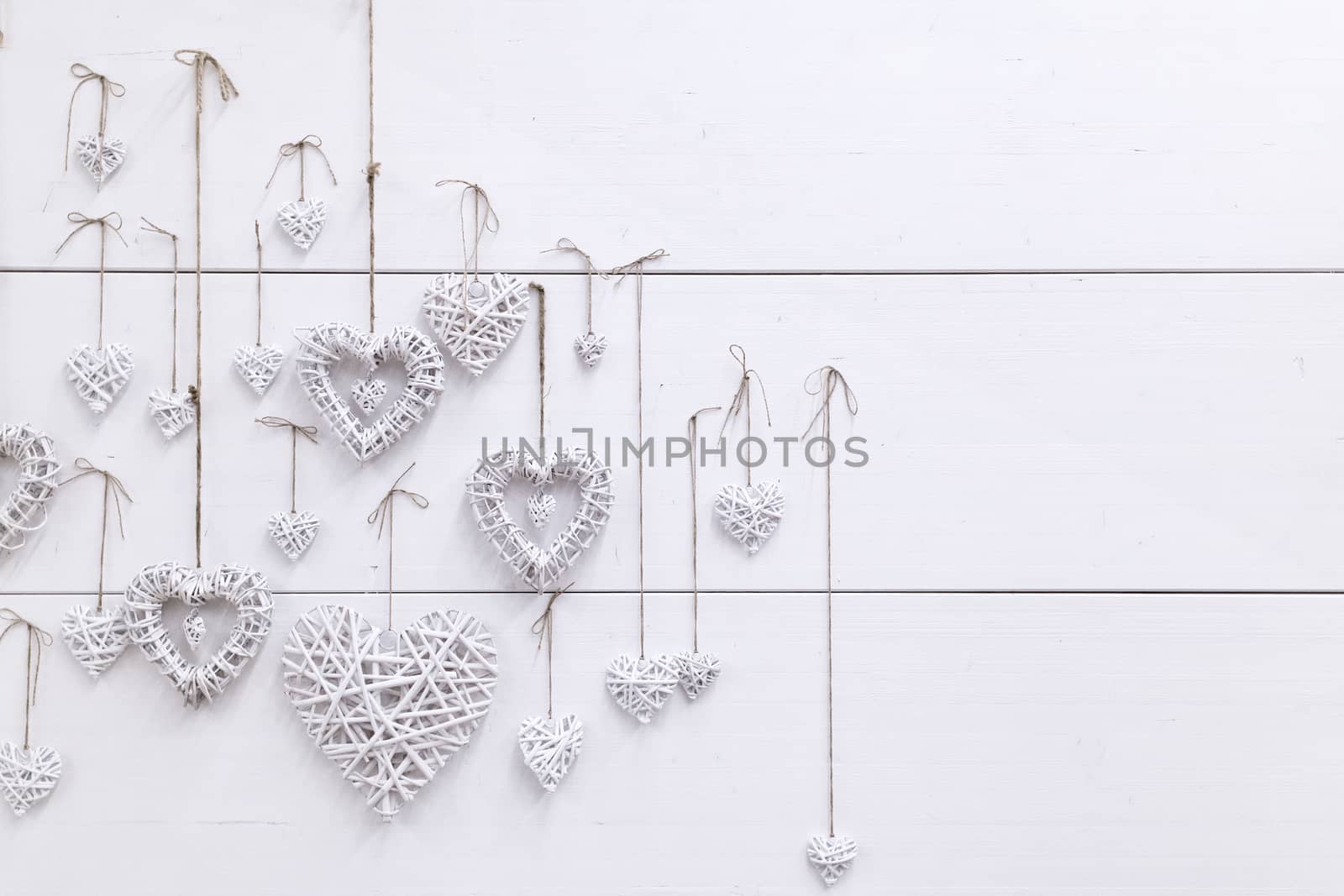 White hearts ,handmade, hanging on a white wall. wedding and love photo