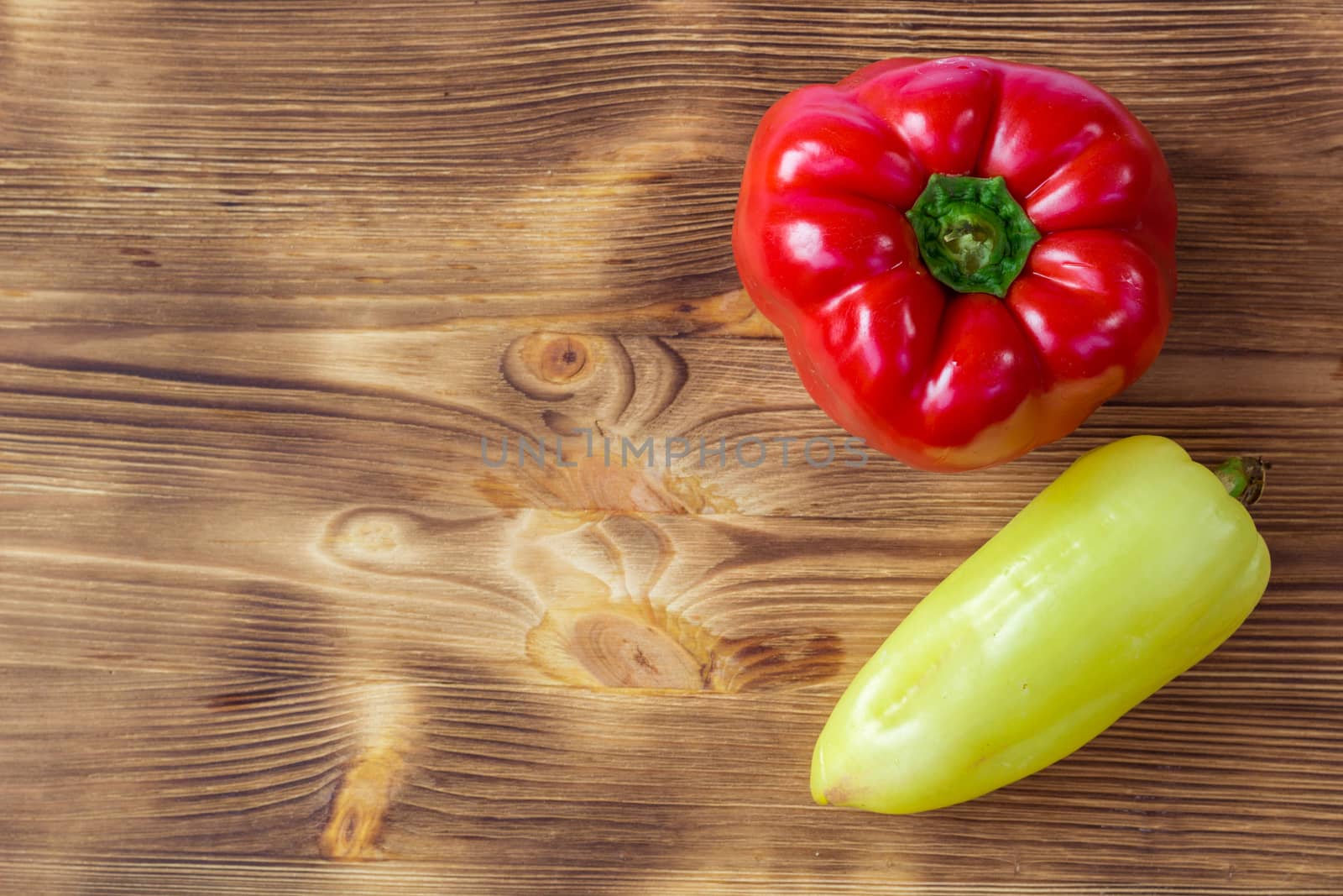 Vegetable background for postcard with two red and green peppers on wooden board