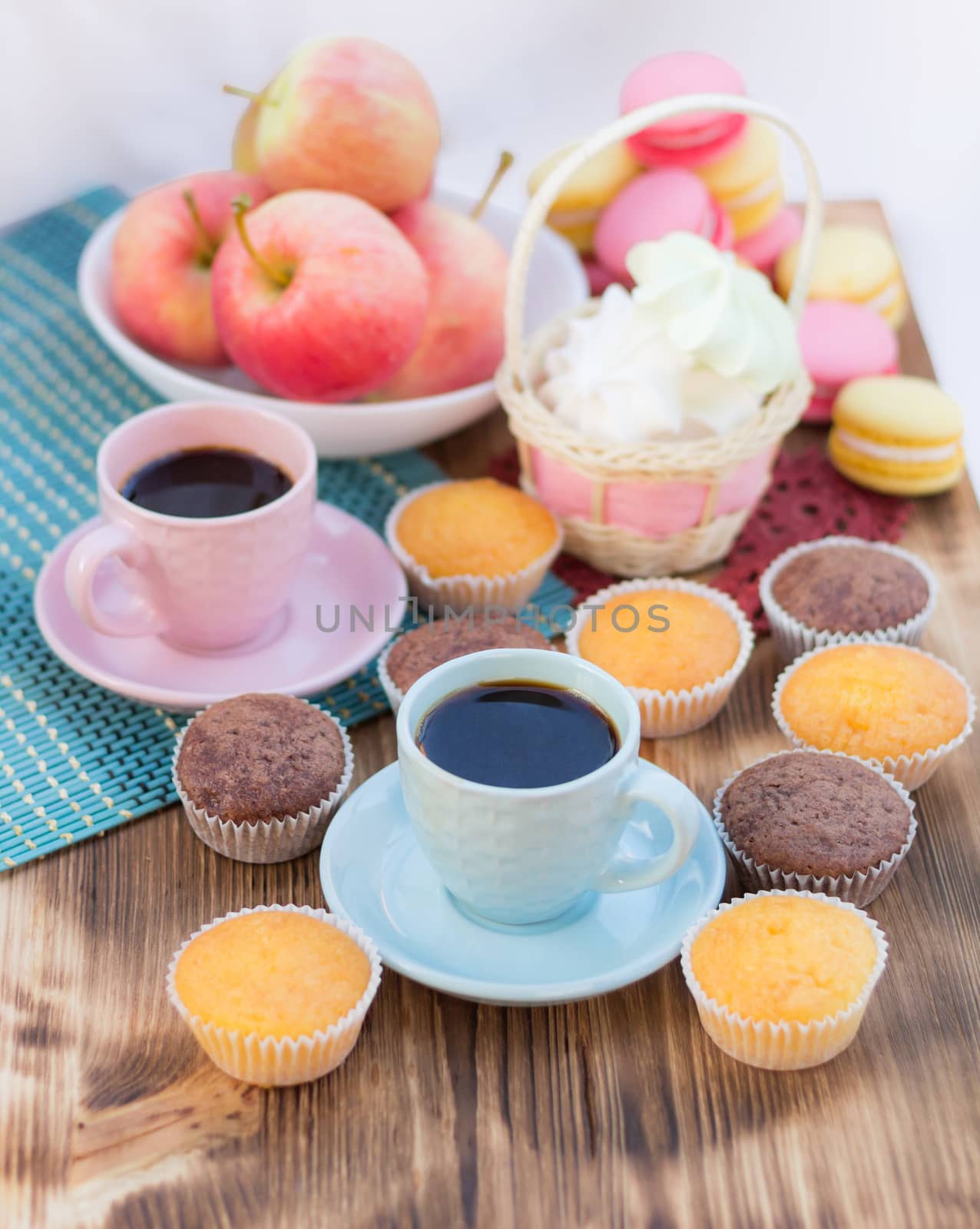 Still life of served coffee cups, macaroon cookies, marshmallows and apples