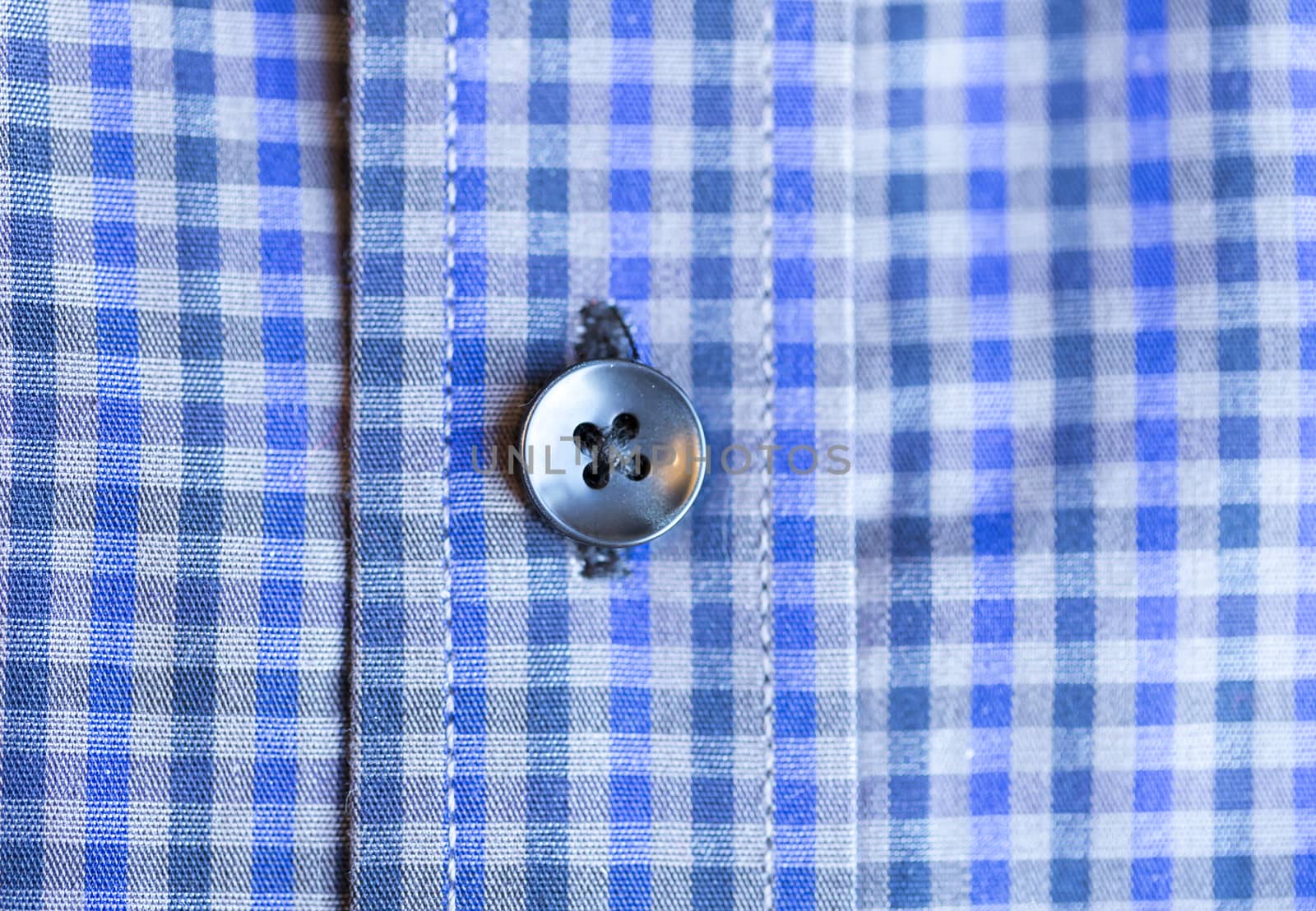 Shirt Button Close Up on blue and white shirt.