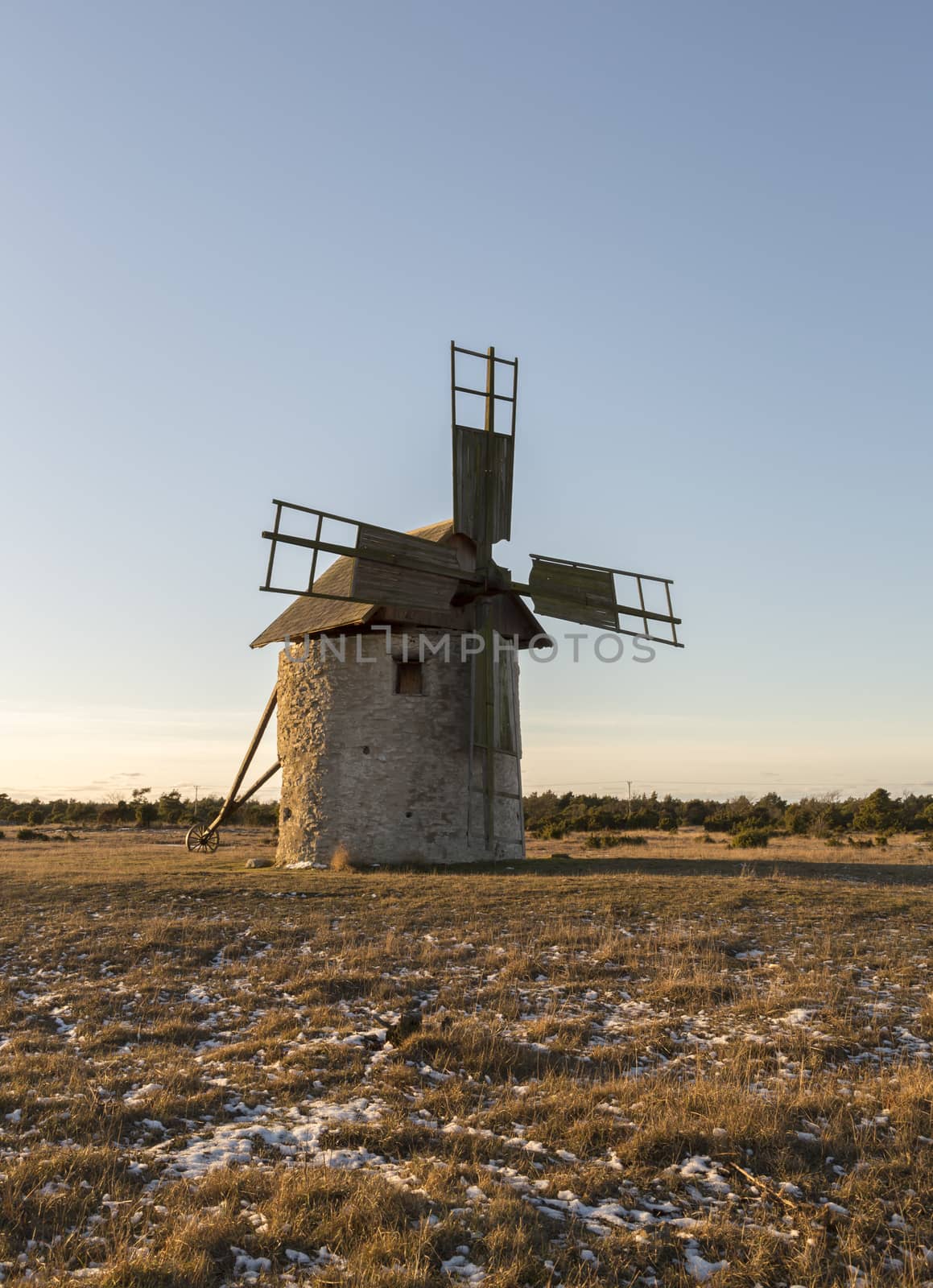 Windmill in Field with grass and snow.