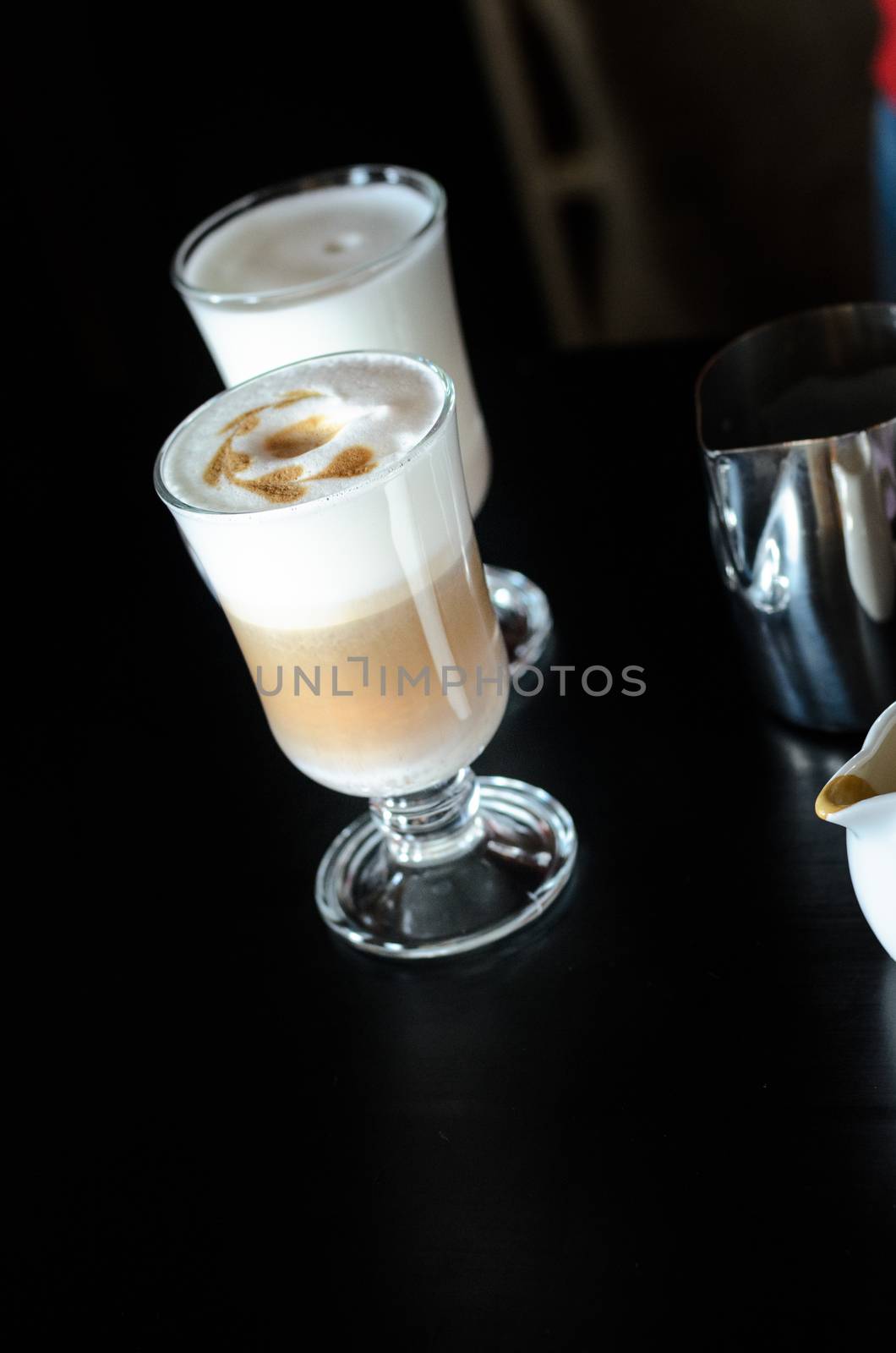 the bartender Barista behind the counter making coffee latte, pouring and prevents