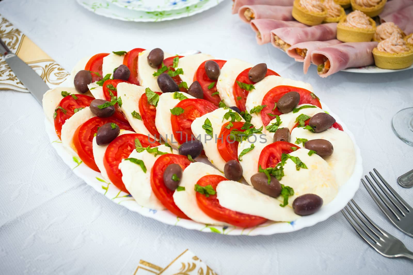 Cocktail food appetizer with slices of mozzarella, tomatoes and olives