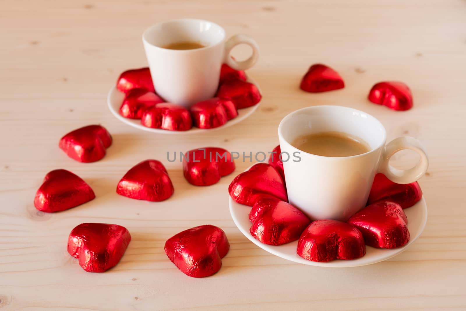 Red chocolate hearts and espresso coffee on a table