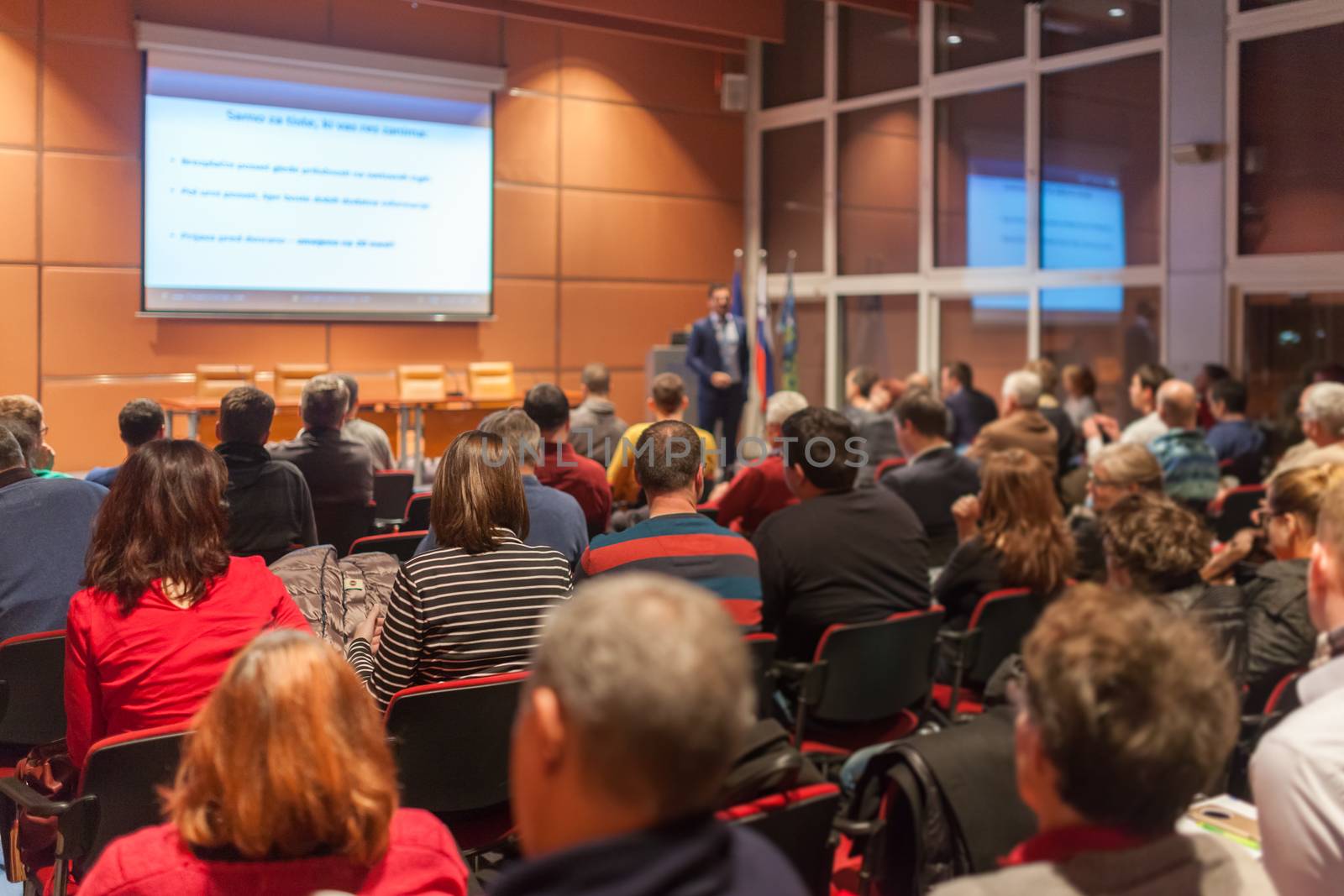 Speaker giving a talk in conference hall at business event. Audience at the conference hall. Business and Entrepreneurship concept.