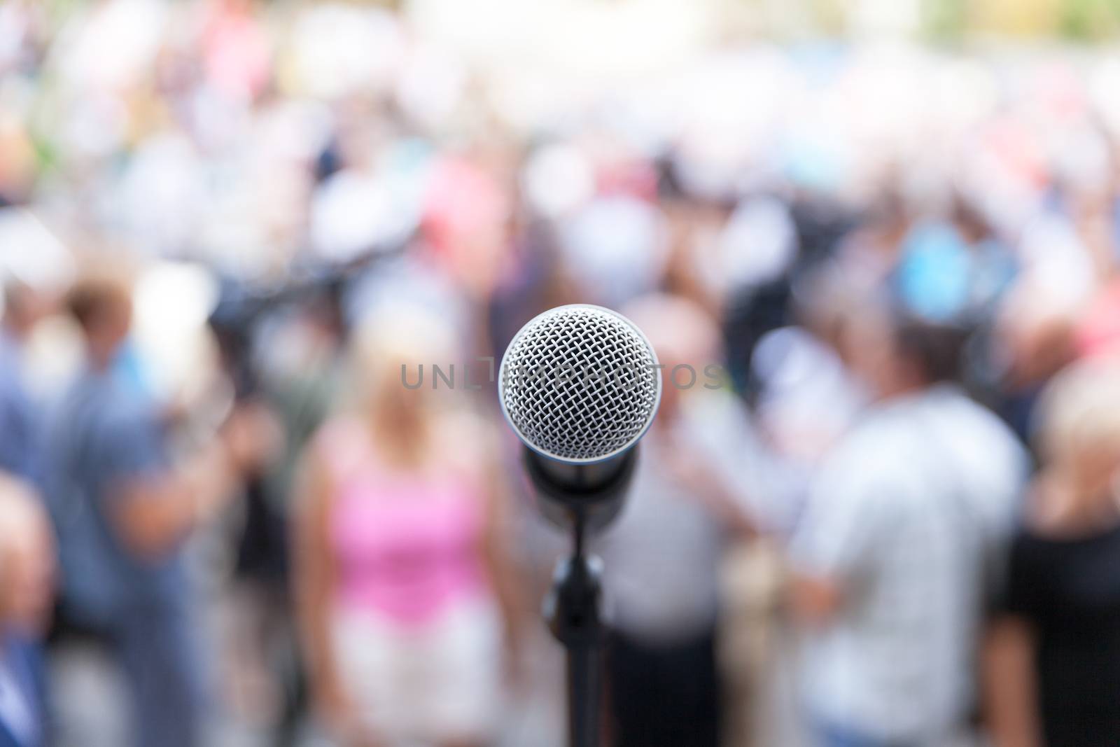 Mic in focus against unrecognizable crowd