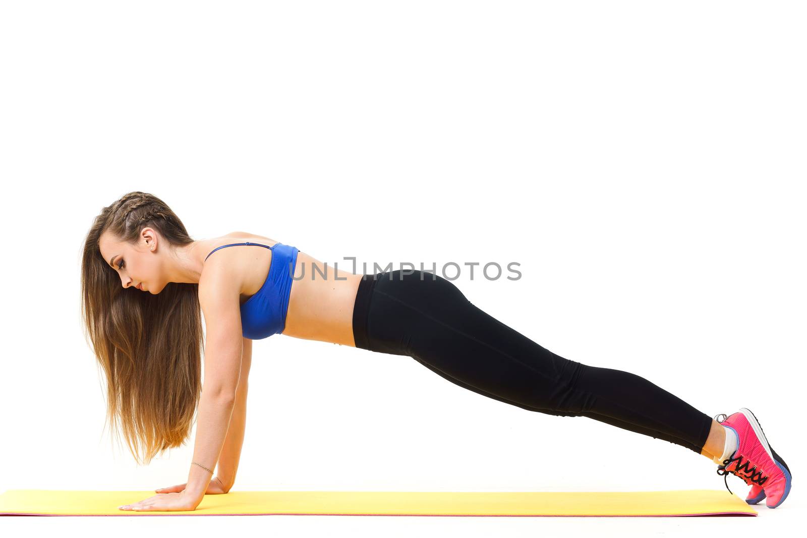 Beautiful trainer working out with yoga mat isolated on white by mrakor