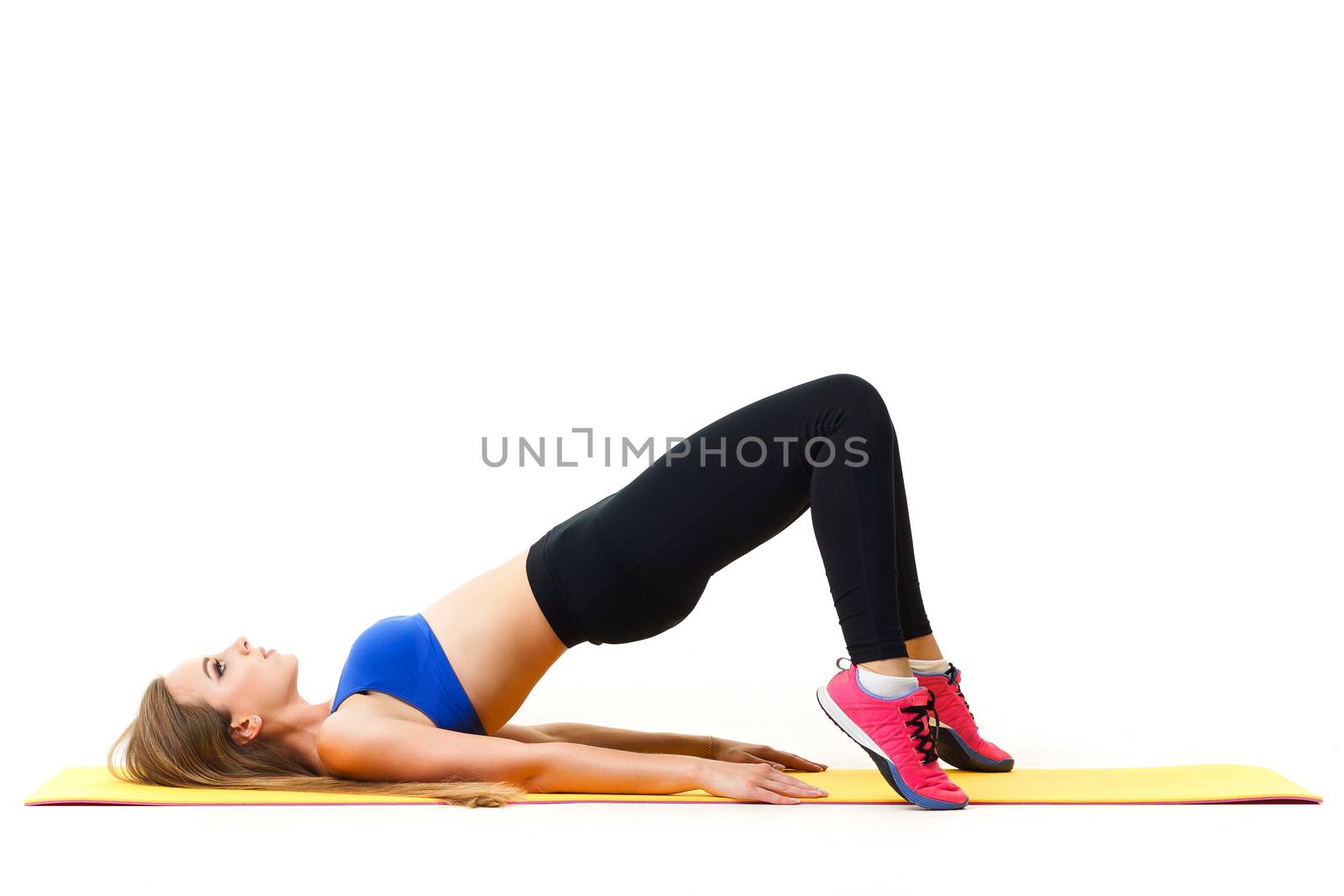 Beautiful trainer working out with yoga mat isolated on white by mrakor