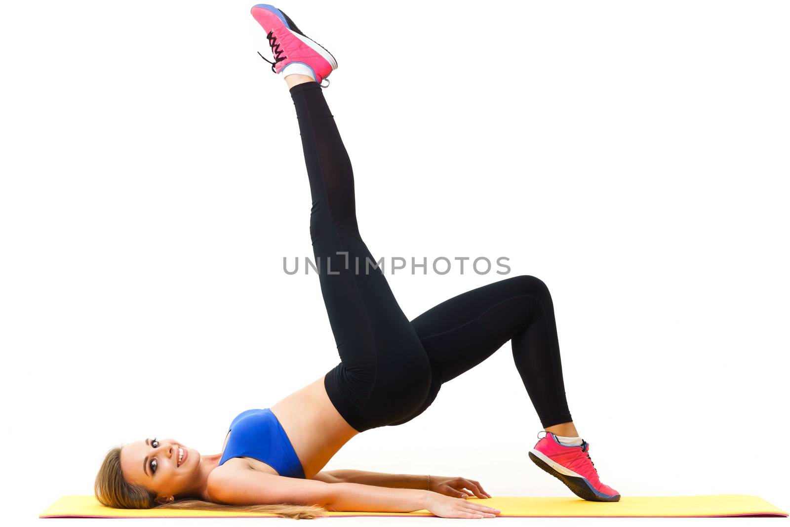 Beautiful trainer working out with yoga mat isolated on white by mrakor