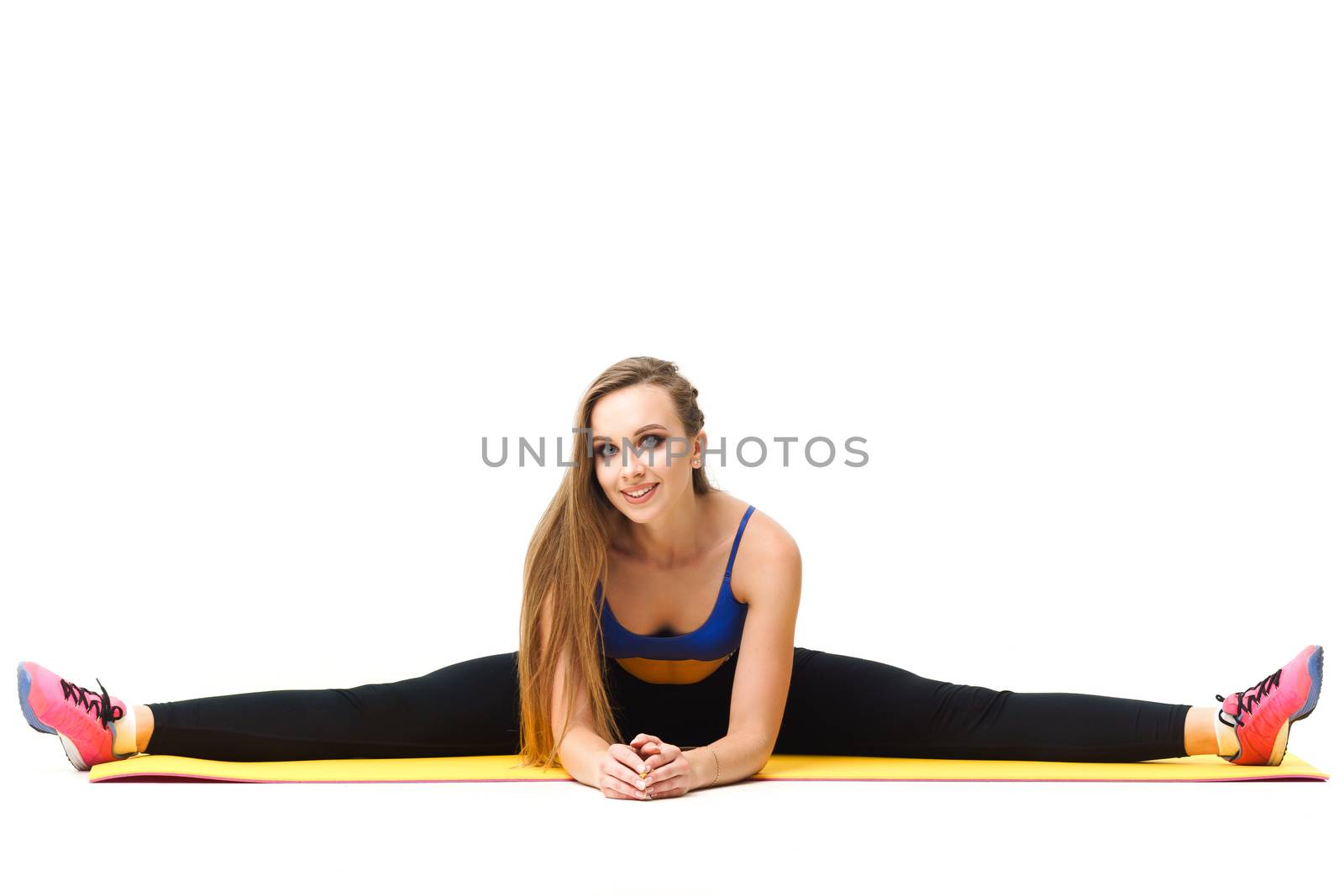 Beautiful trainer working out with yoga mat isolated on white by mrakor