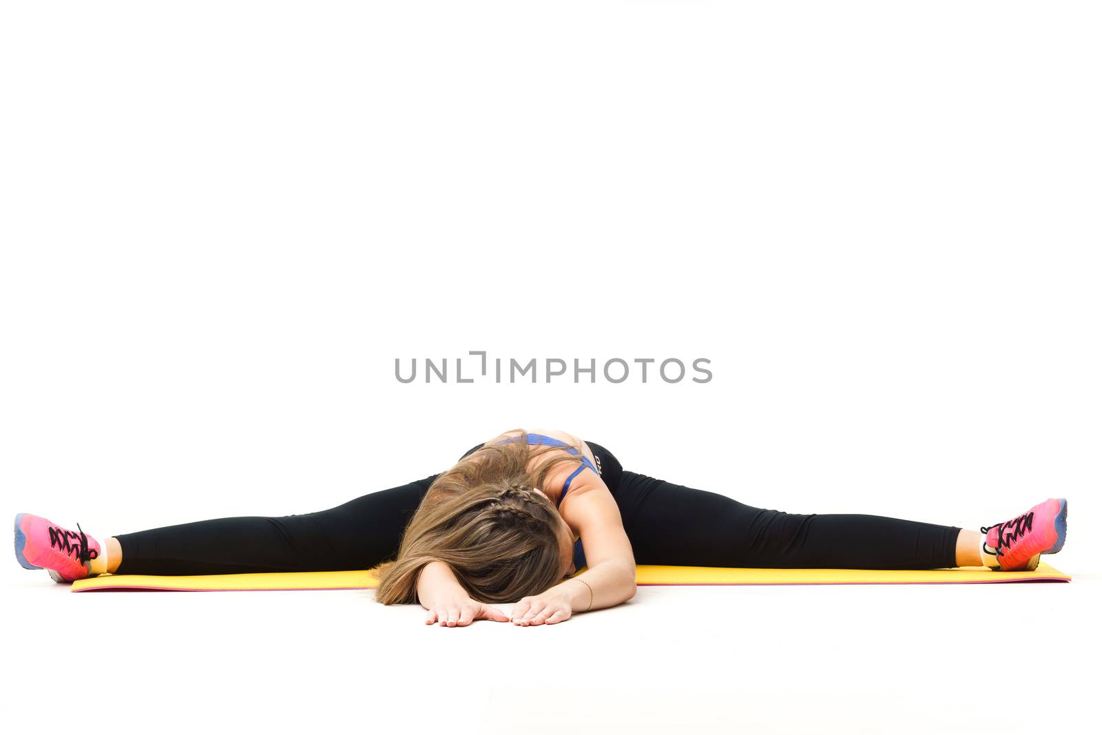 Beautiful trainer working out with yoga mat isolated on white by mrakor