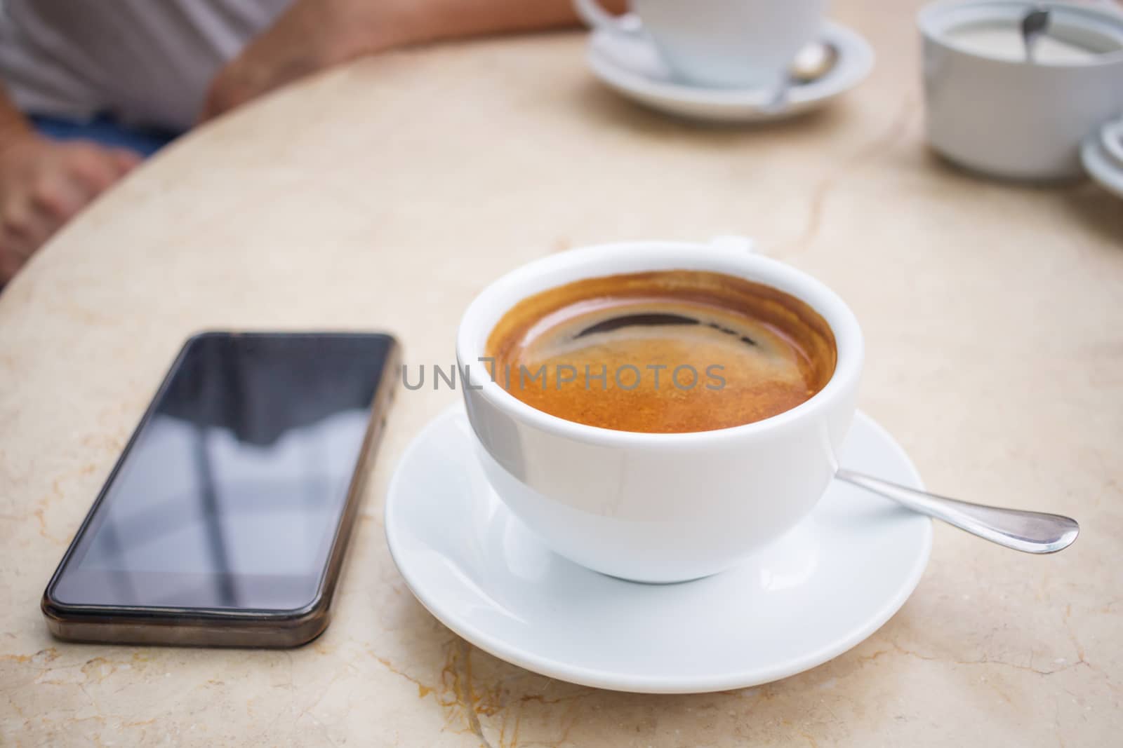 Coffee break in cafe, cup of coffee and smartphone on marble table top