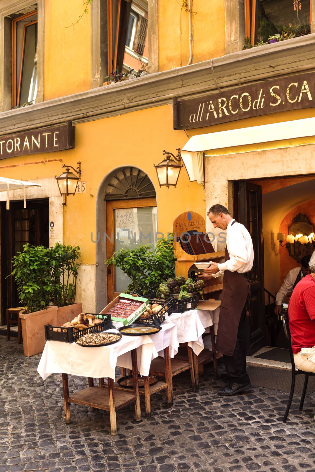 Rome, Italy - May 27, 2016: Unidentified people eating traditional italian food in outdoor restaurant in Trastevere district in Rome, Italy.