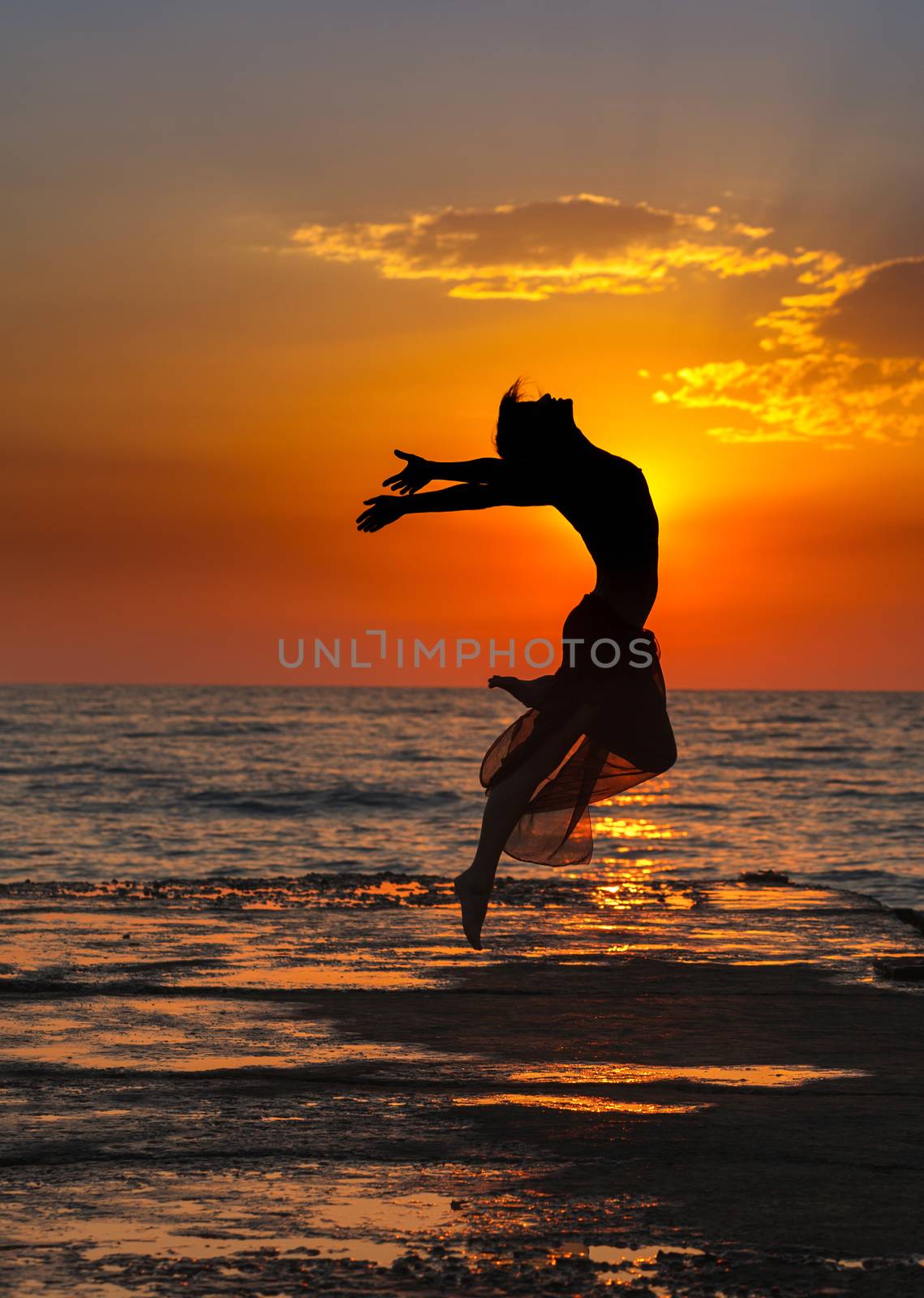 Girl jumping on a background of sea sunset
