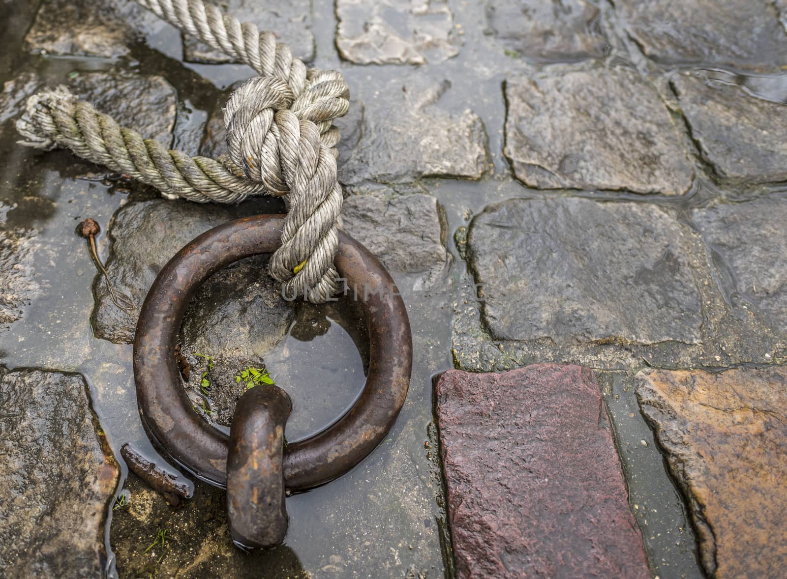 Close up image with a solid iron ring used to secure the anchoring of the ships on the docks, called mooring ring.