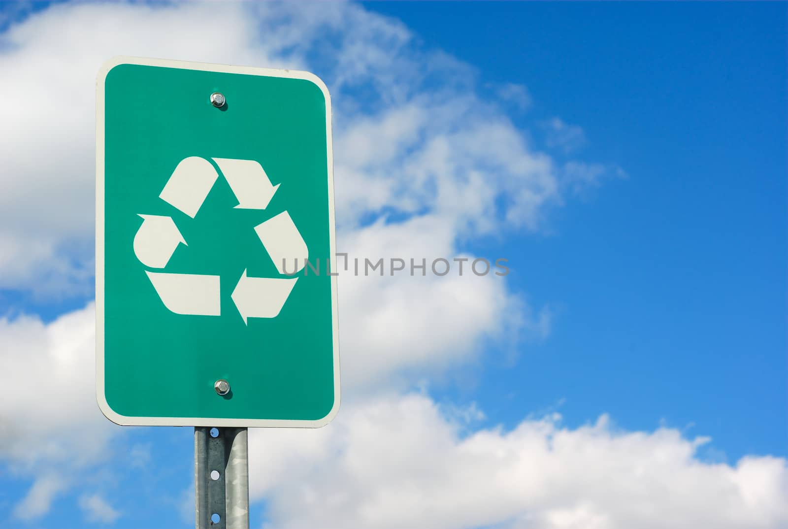 green real recycling panel sign on blue sky by jacquesdurocher