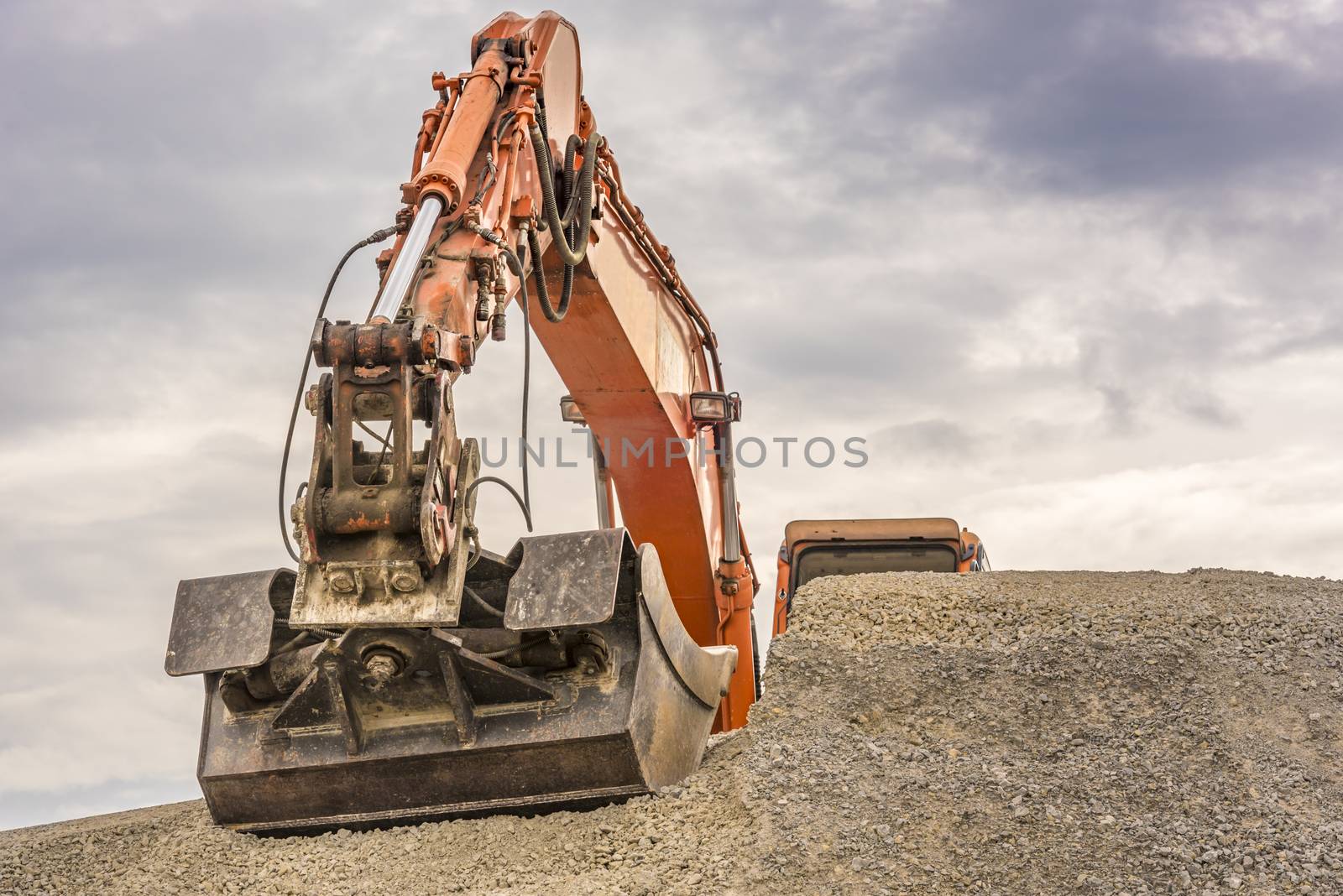 Frontal close up with the bucket and arm from a big orange excavator