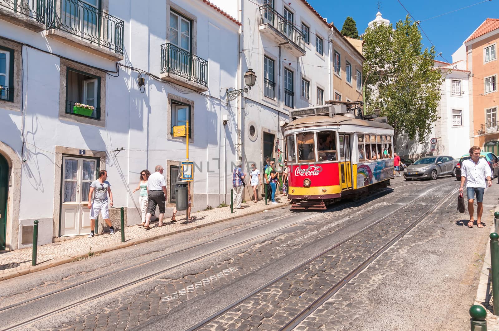 LISBON, PORTUGAL - AUGUST 23: Famous Lisbon tram number 28 on the street of Alfama district on 23 August, 2014 in Lisbon. Trams keep the traditional style of the historic center of Lisbon.