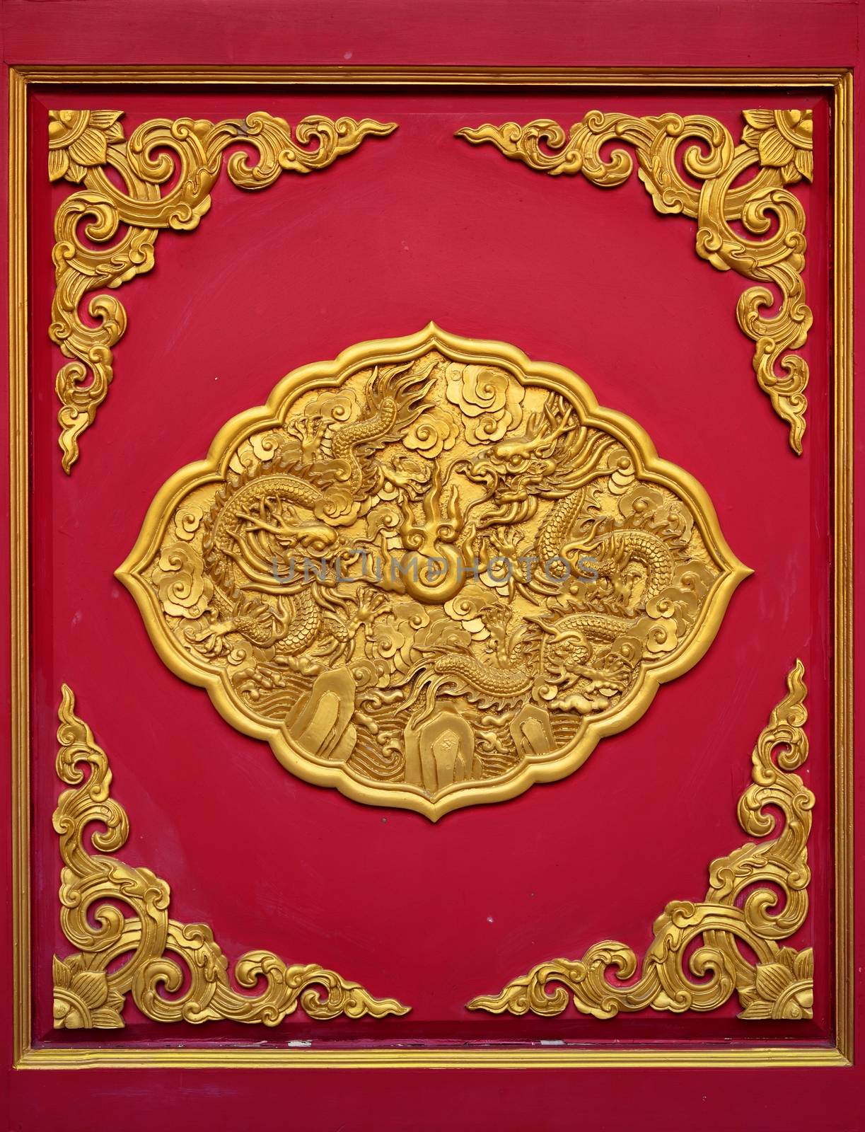 The golden dragon on the red door of Chinese temple in Thailand