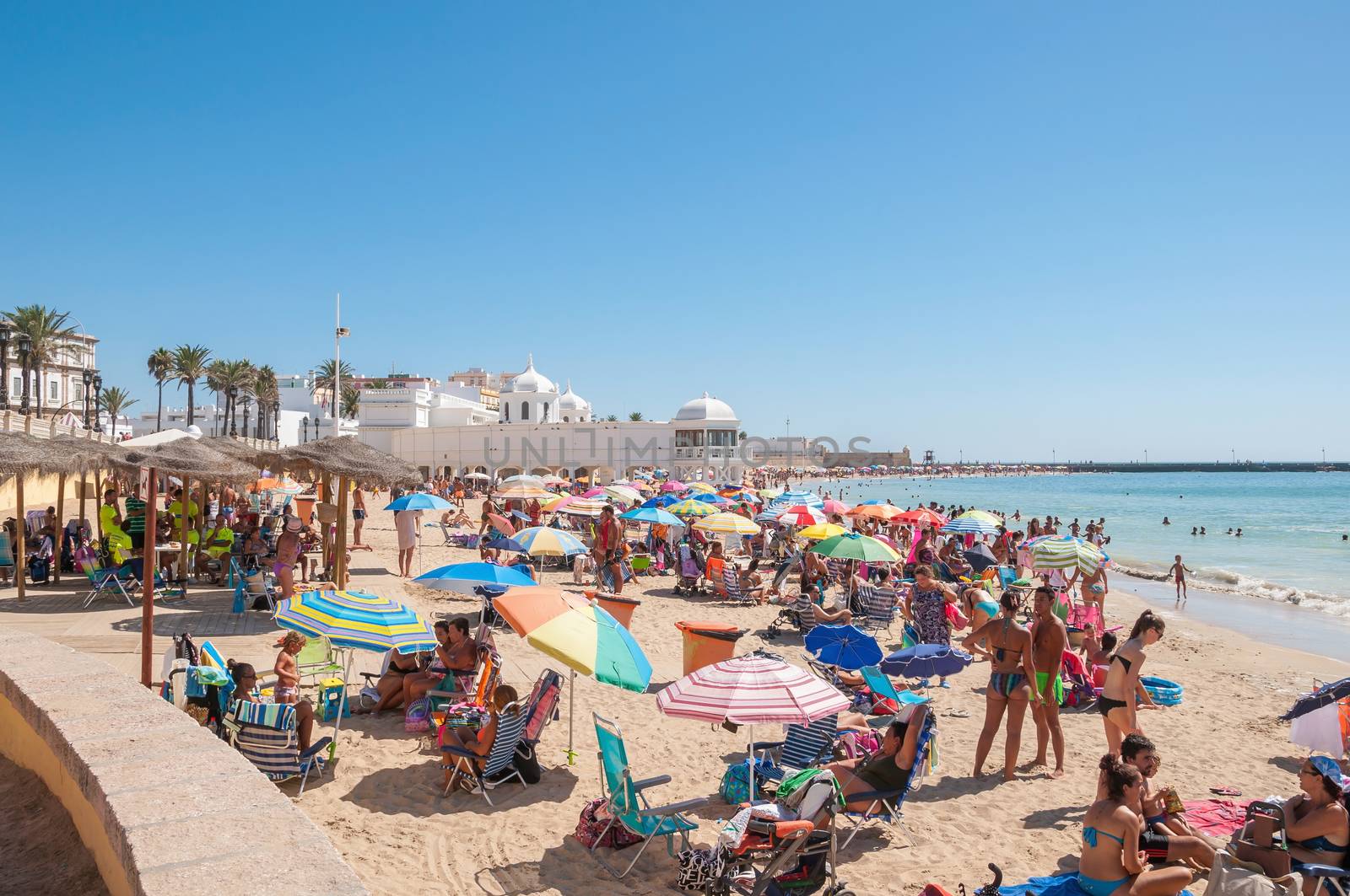 CADIZ, SPAIN - AUGUST 27, 2014: People sunbathing on Caleta Beach, small and very popular beach located in Cadiz city center.