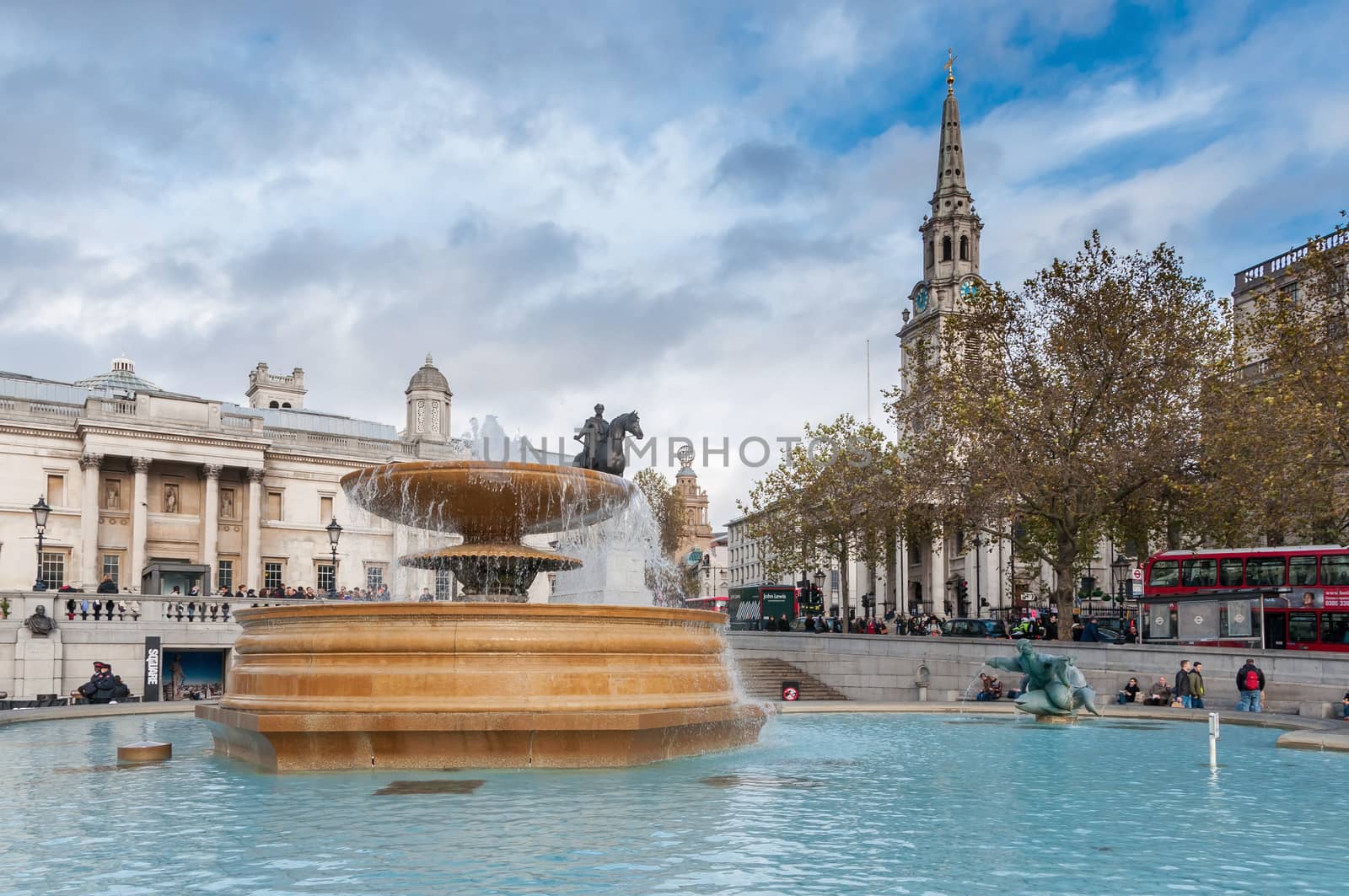 Fountain at crowded Trafalgar Square by mkos83