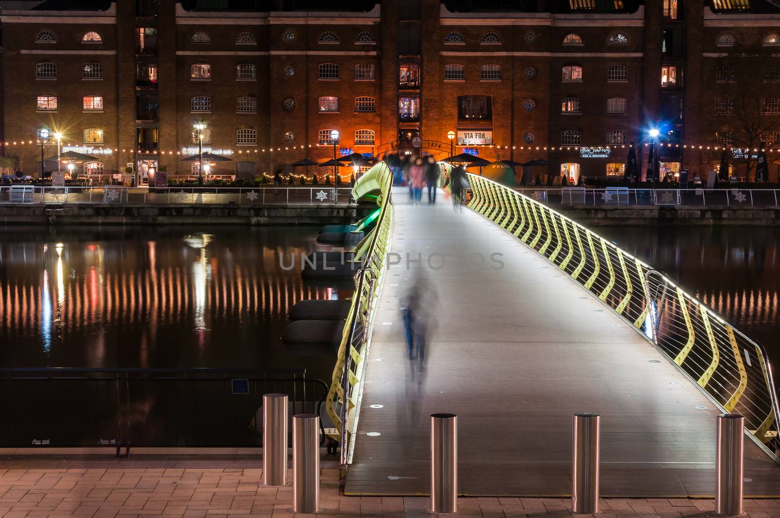 Illuminated foot bridge in over North Dock in Canary Wharf by night by mkos83