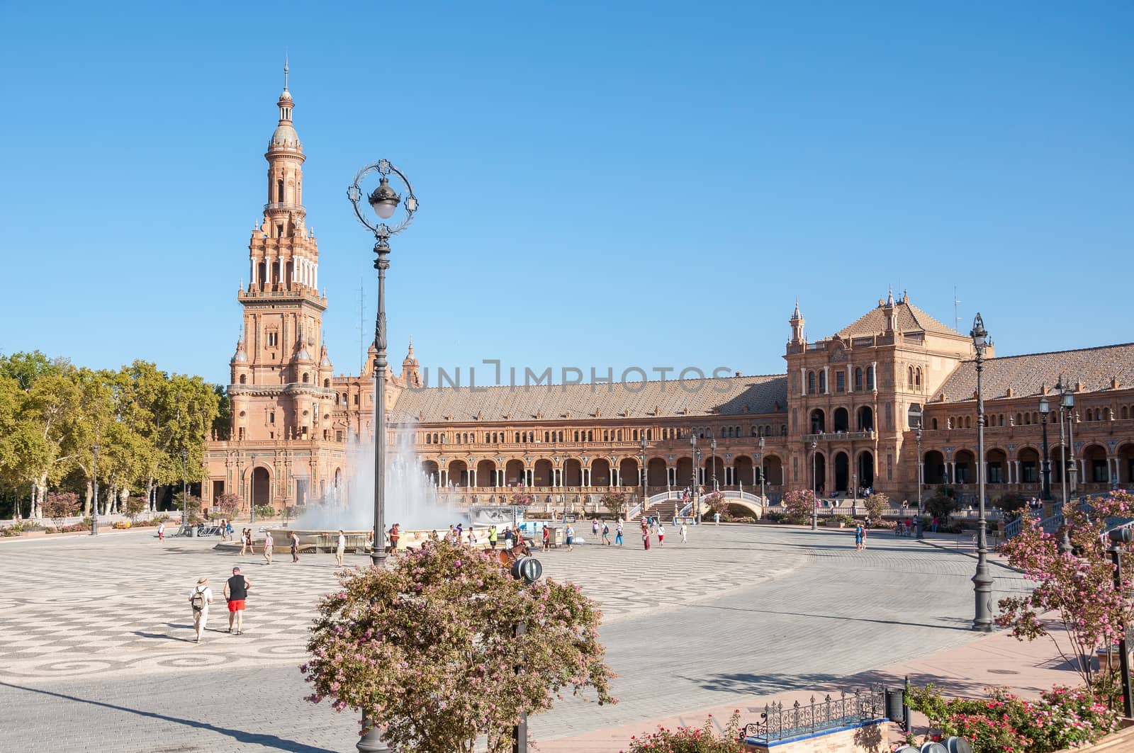 Seville, Spain - August 28, 2015: Tourists visit Plaza de Espana in Seville. It is a landmark example of the Renaissance Revival style in Spanish architecture.