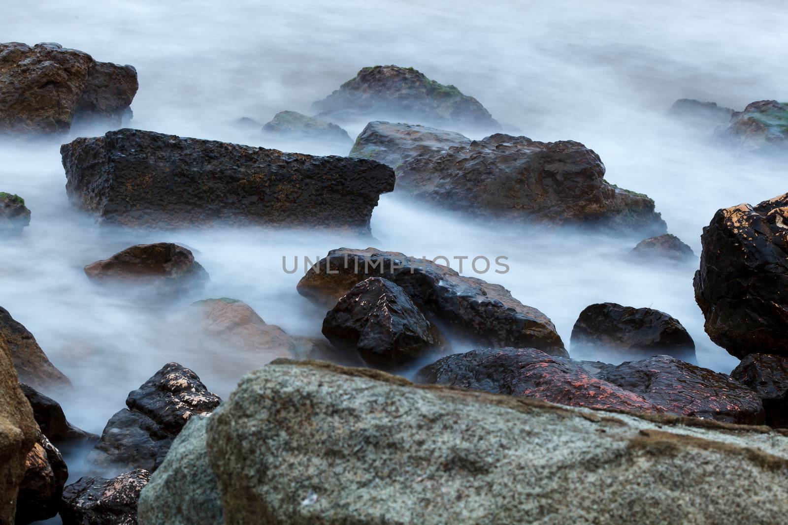 Morning fog over the rocky shore of the sea